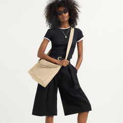 hover | The Mini Zip Bucket in Knot Brown, carried over the shoulder of a female model, shown from the front.