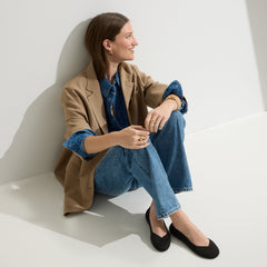 hover | The Flat round toe shoe in Black Solid shown on-model at an angle.