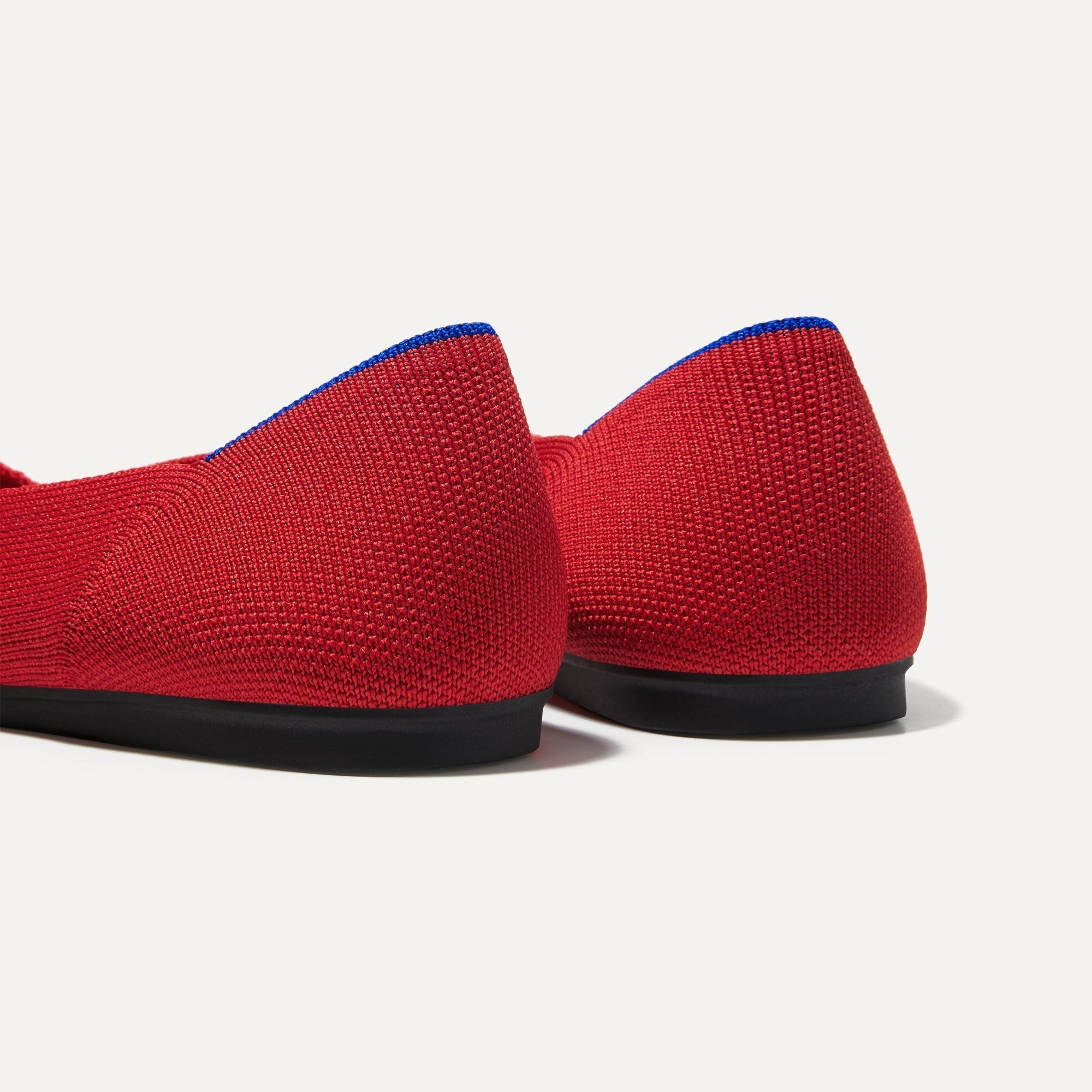 Close up of the heel of The Flat in Bright Red, with Rothy's signature blue halo. 