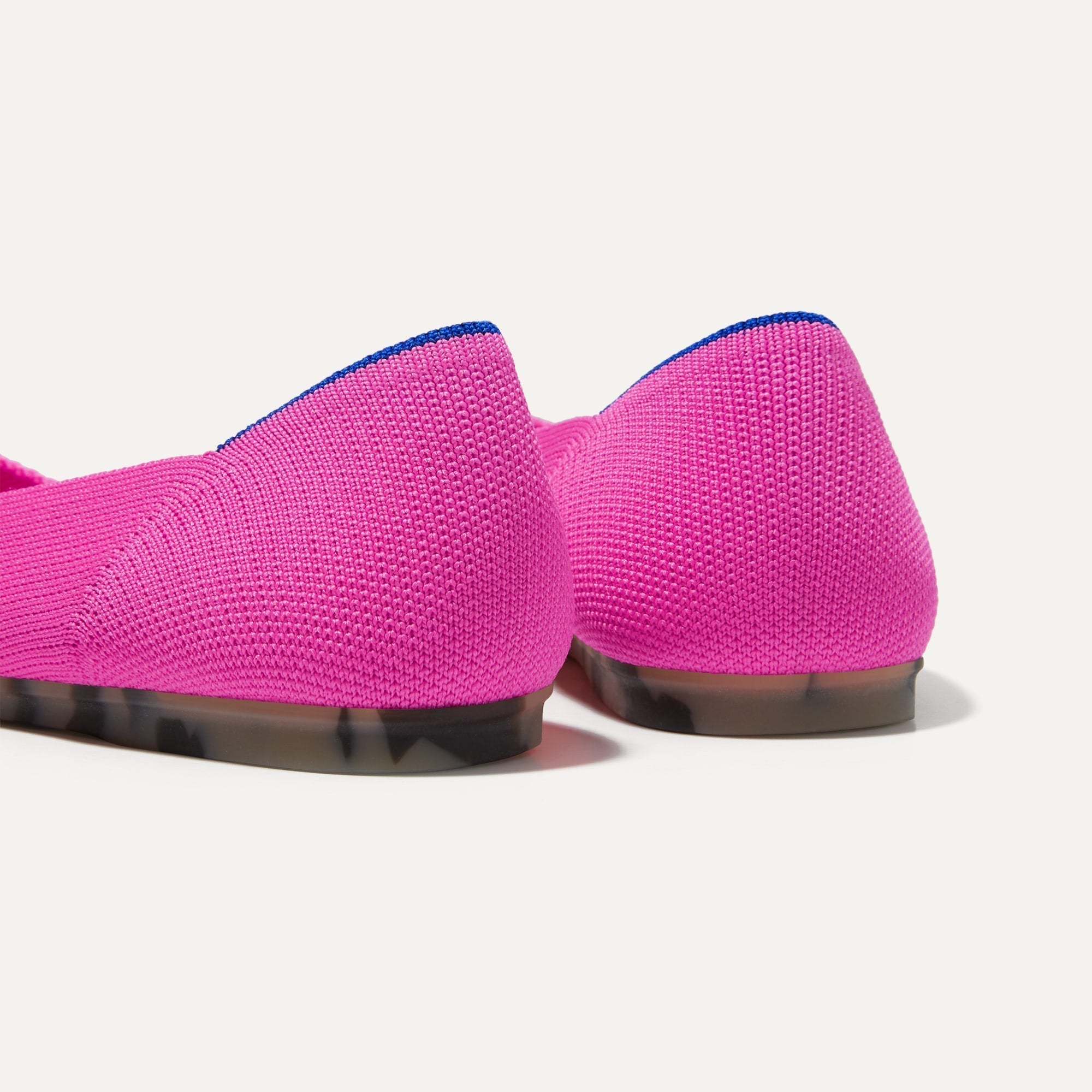 Close up of the heel of The Flat in Dragon Fruit, with Rothy's signature blue halo. 