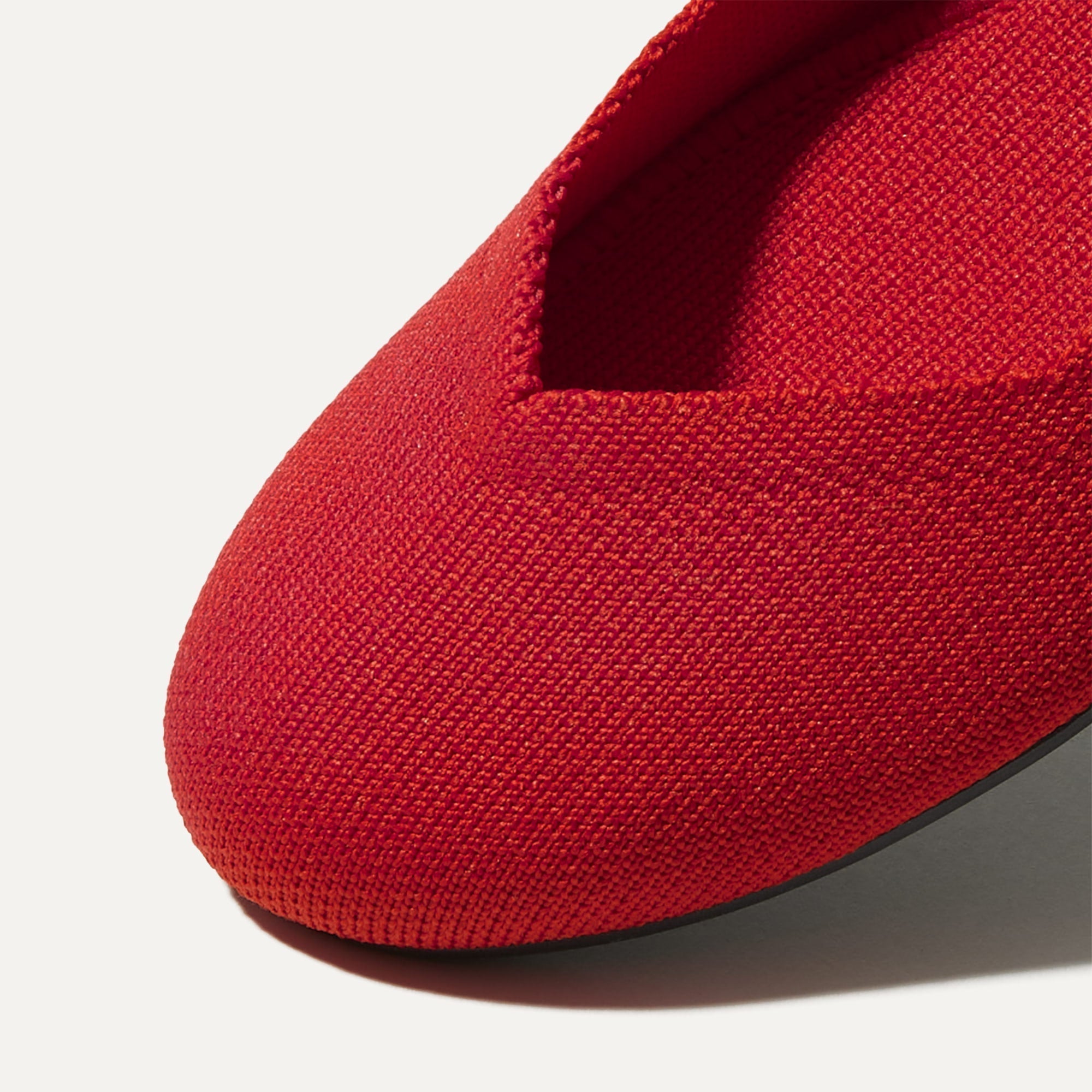 Close up of the rounded toe and v-shaped vamp of The Flat in Bright Red.