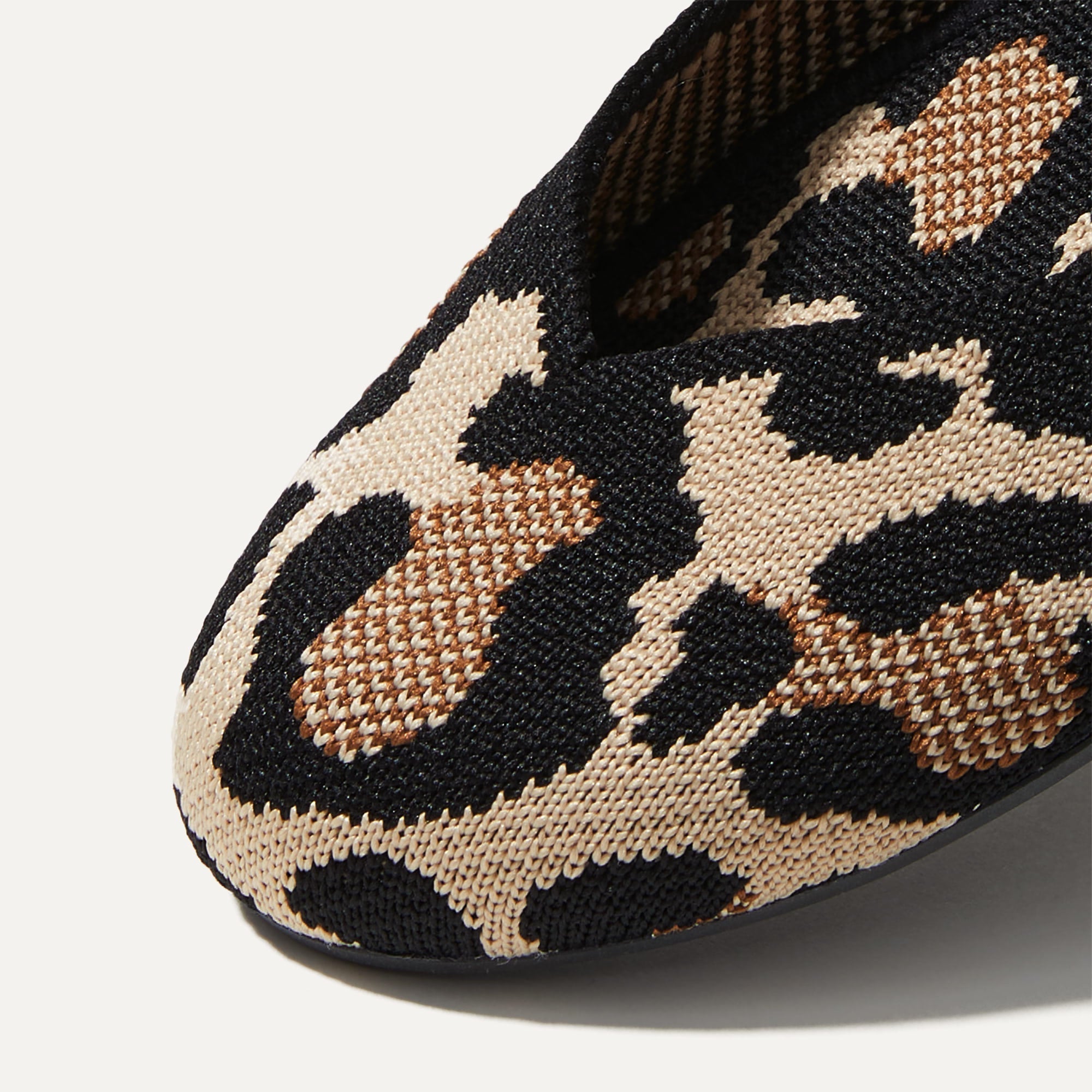 Close up of the rounded toe and v-shaped vamp of The Flat in Desert Cat.
