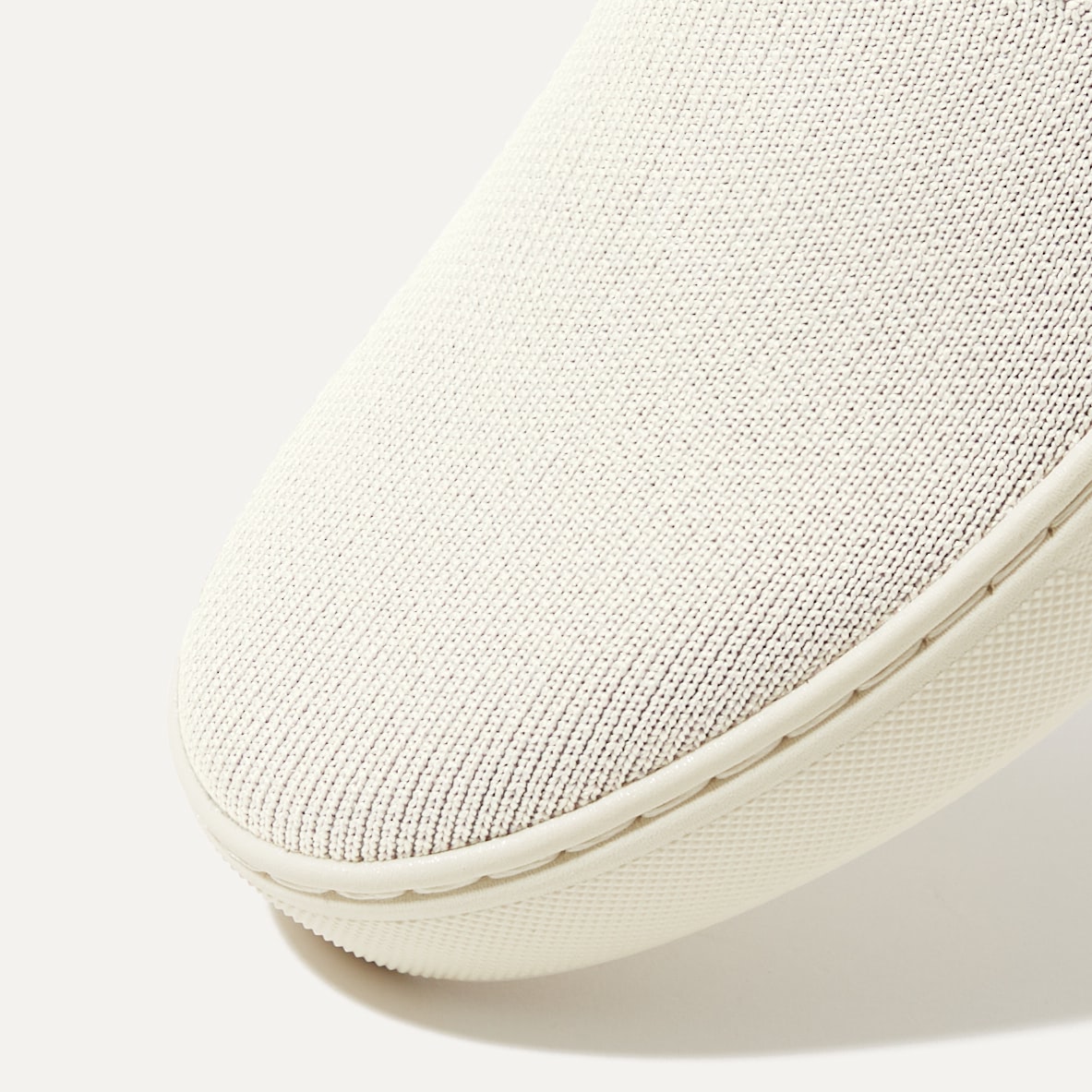 Close up of the toe and vamp of The Original Slip On Sneaker in Antique White.