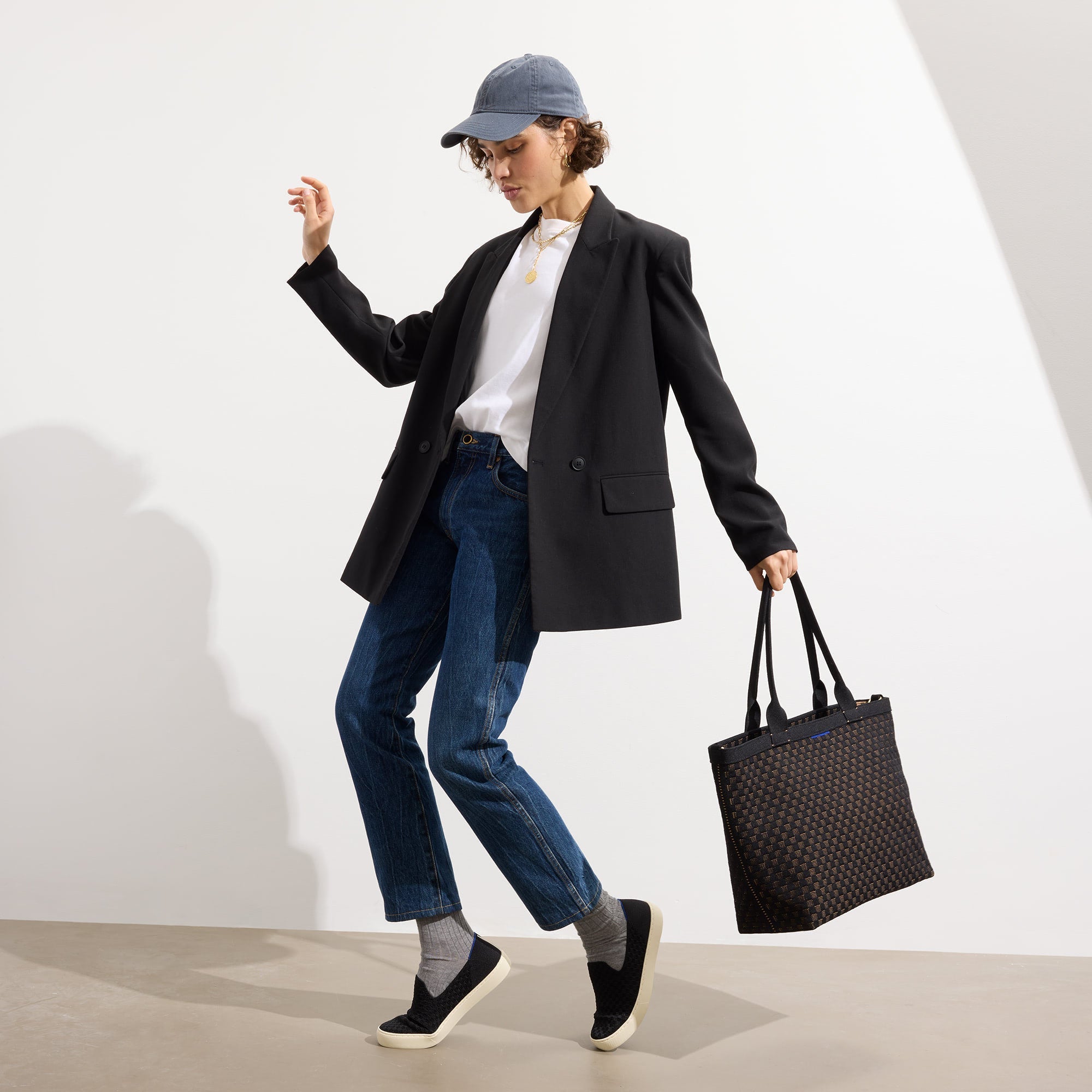 An alternate view of a model holding The Lightweight Zip Tote in Night Song.