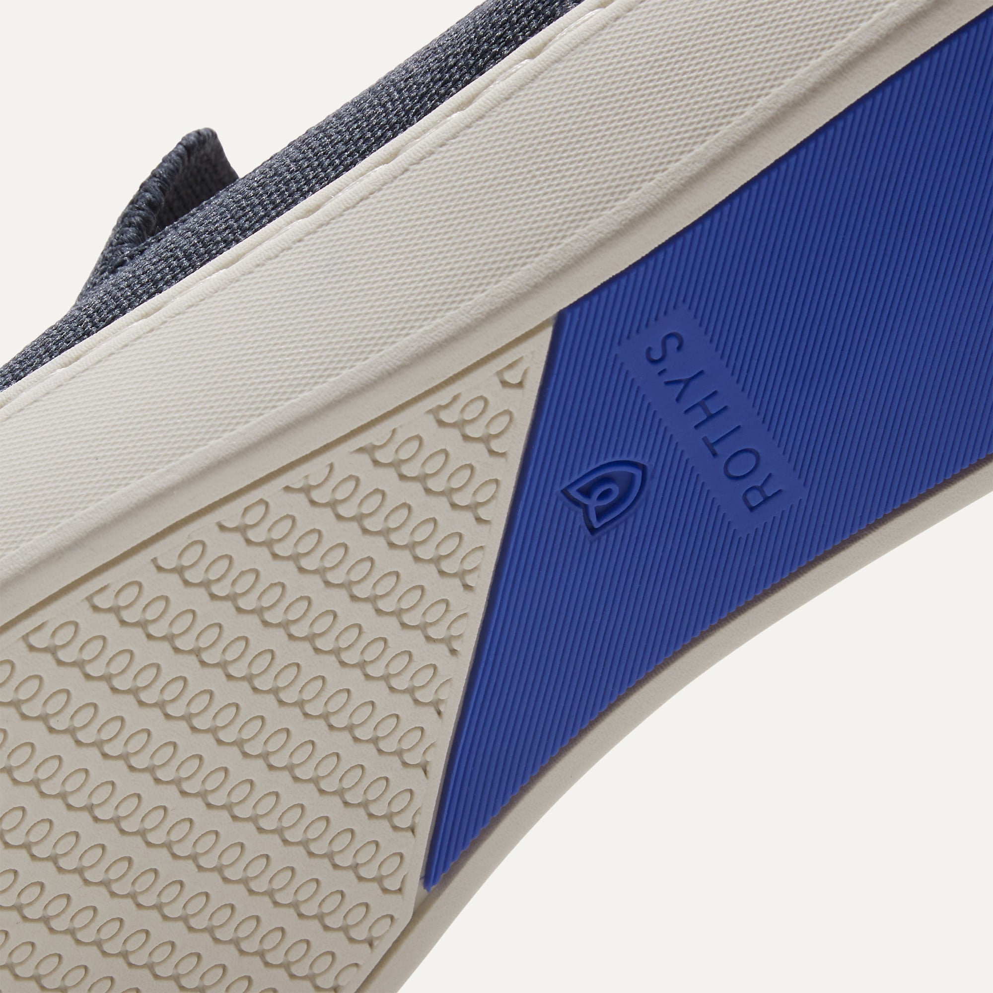 The sole of The Sneaker in Navy shown in diagonal view.