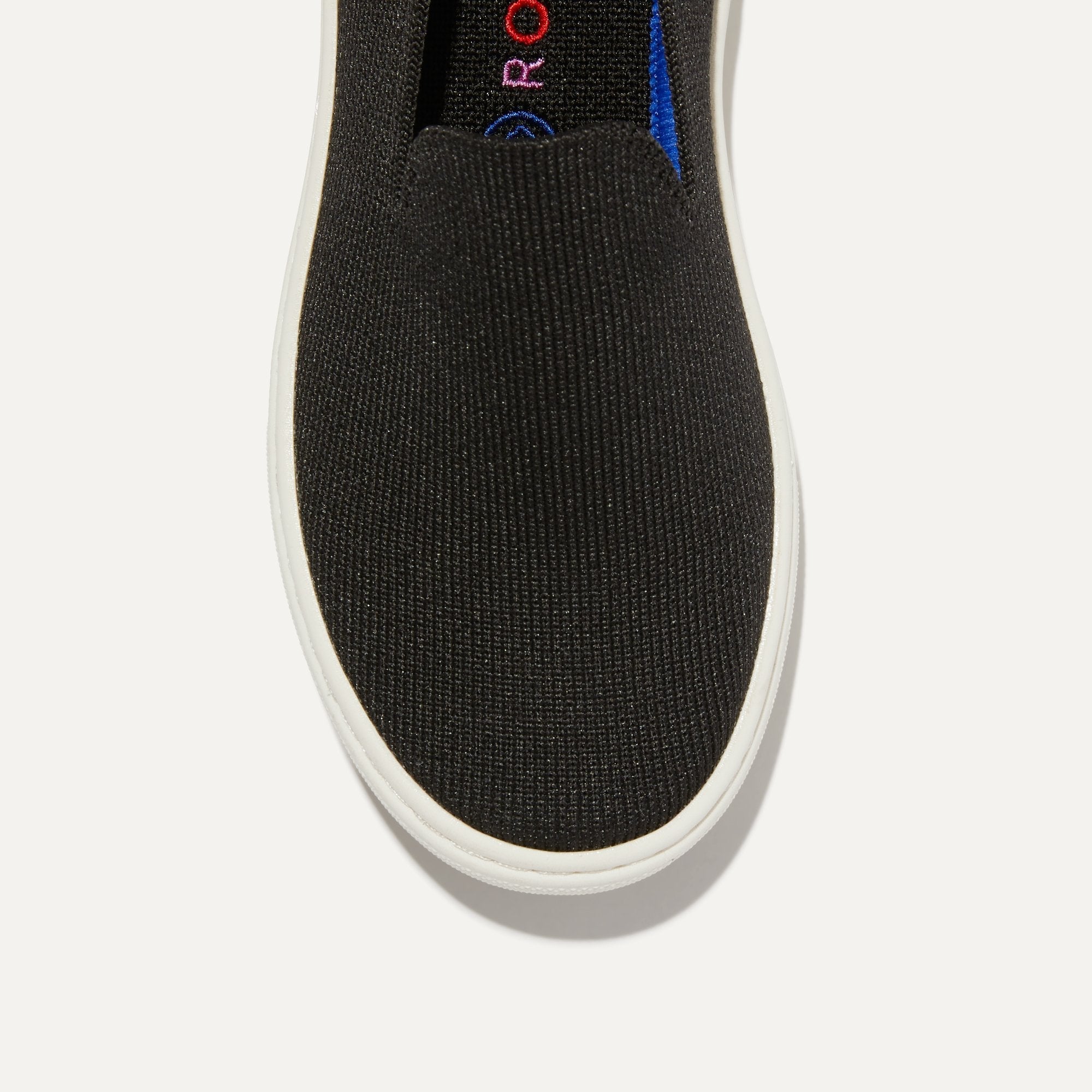 The Kids slip-on Sneaker in Black shown from the top view with detailing of the front of the shoe.
