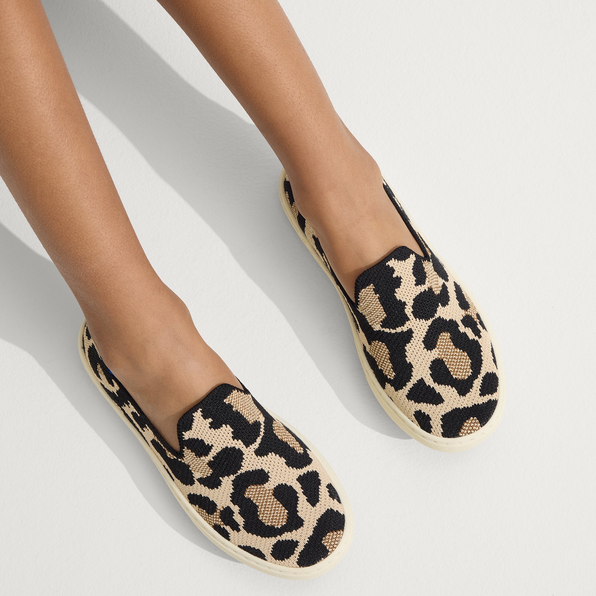 hover | Model wearing The Kids Sneaker in Desert Cat.