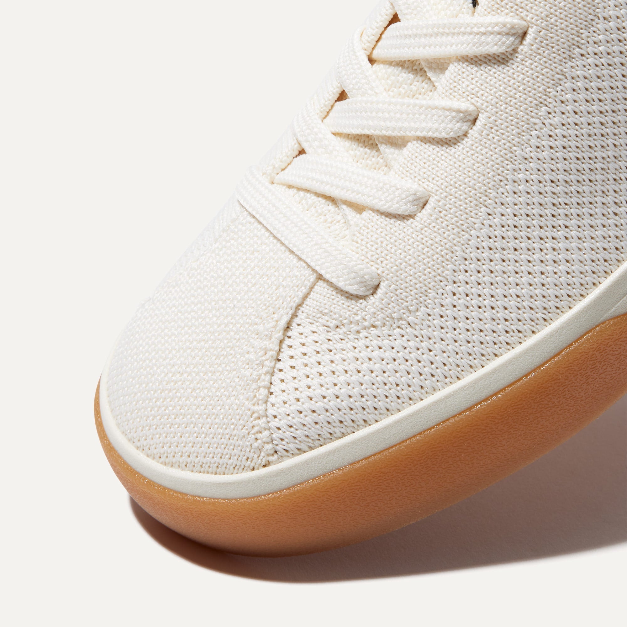 Close up of the toe and stitching details of The Lace Up Sneaker in Blonde.