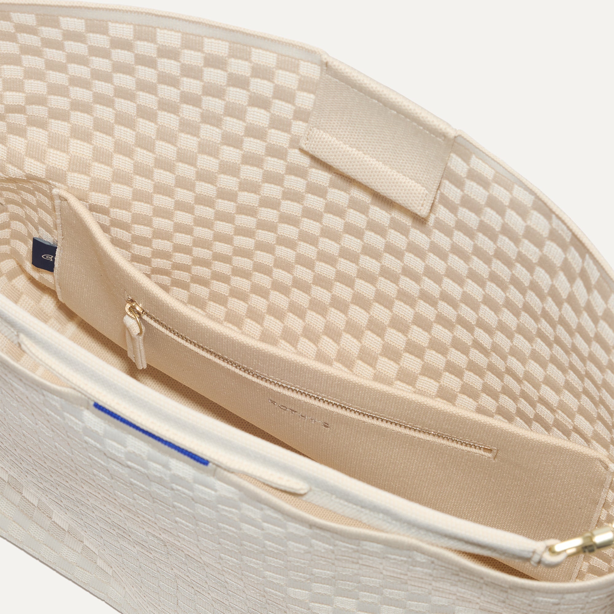 The Bucket Bag in White Sand close up of interior zipper pocket.