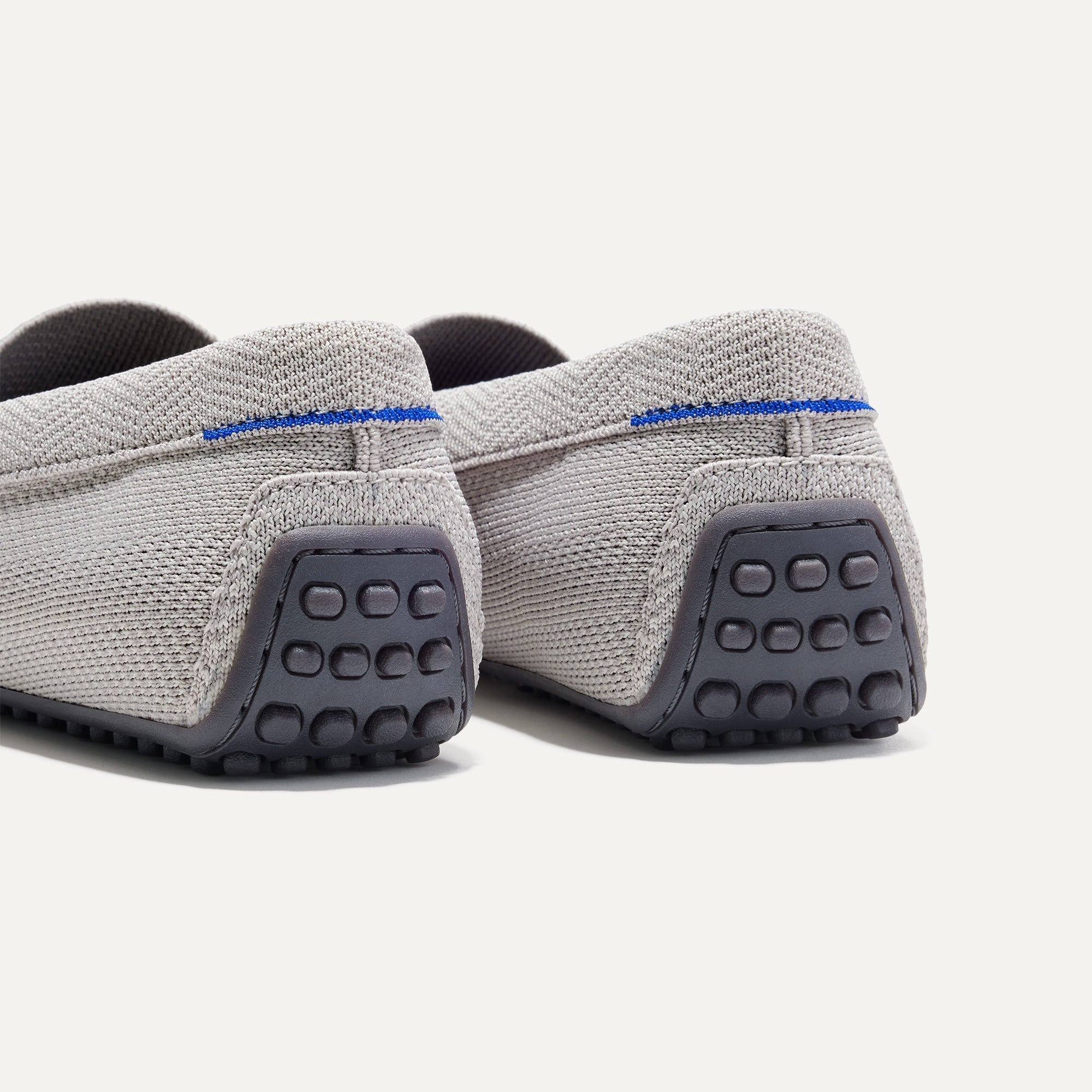 Close up of the heel of The Driving Loafer in Light Grey Herringbone, with raised nub outsoles and Rothy's signature blue halo. 