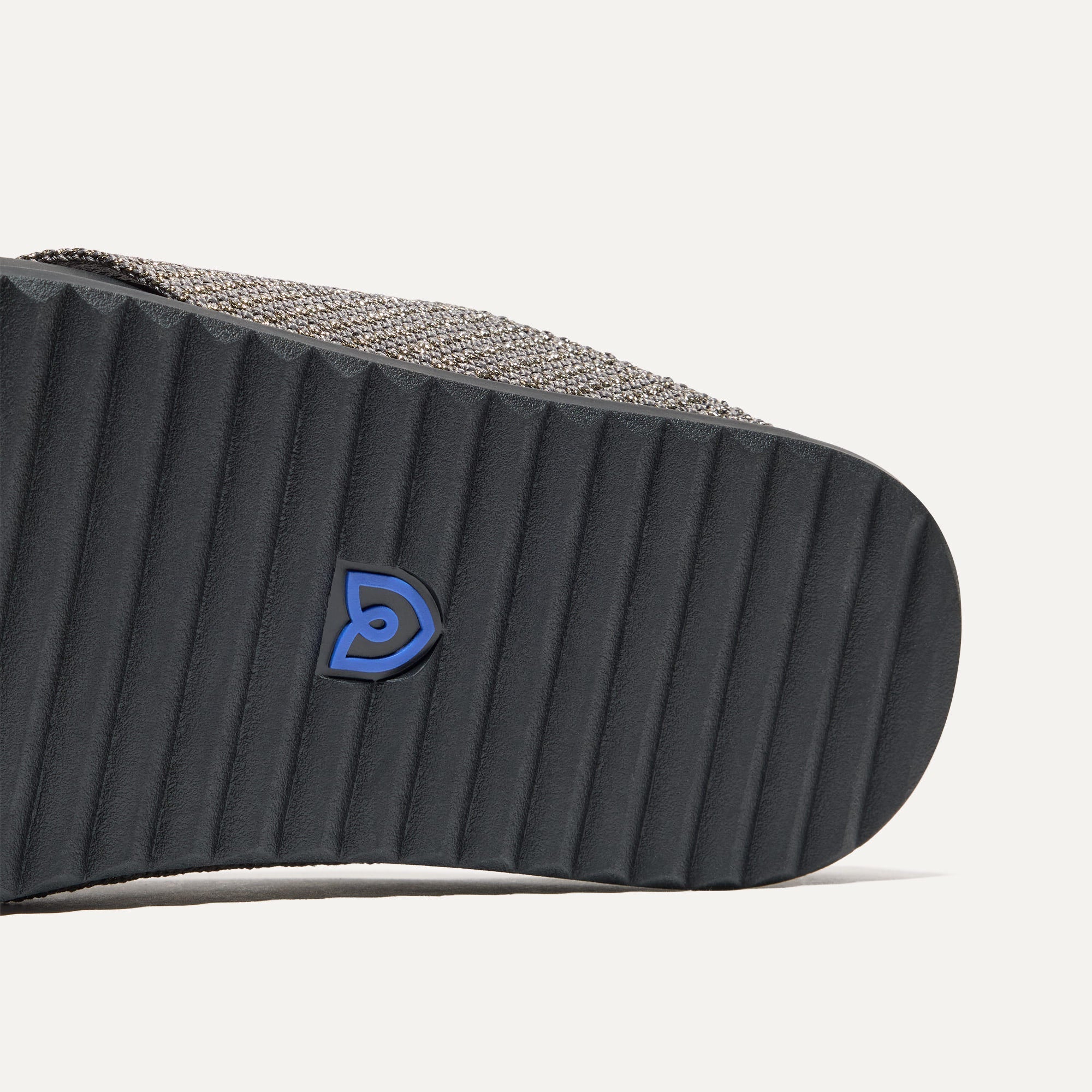 Close up of the outsole of The Weekend Slide in Silver Sand, shown in a diagonal view. 