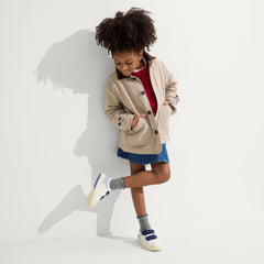 A child modeling The Kids Strap Sneaker in Blue Raspberry.