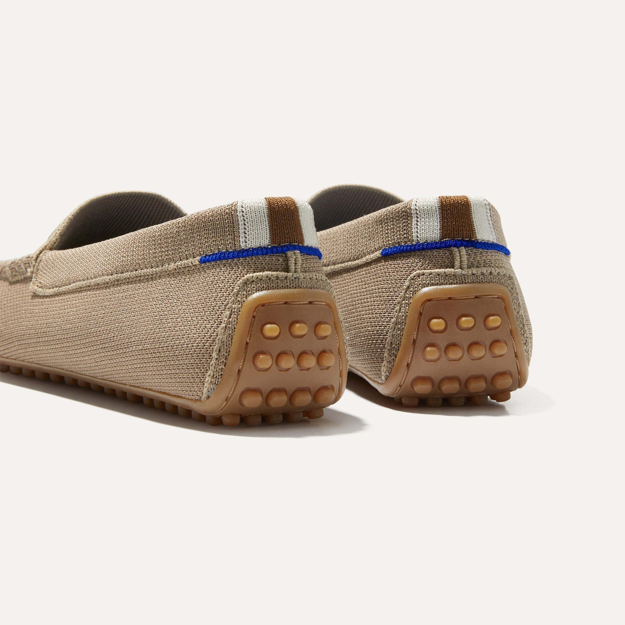 Close up of the heel of The Driver in Latte, with raised nub outsoles and Rothy's signature blue halo. 