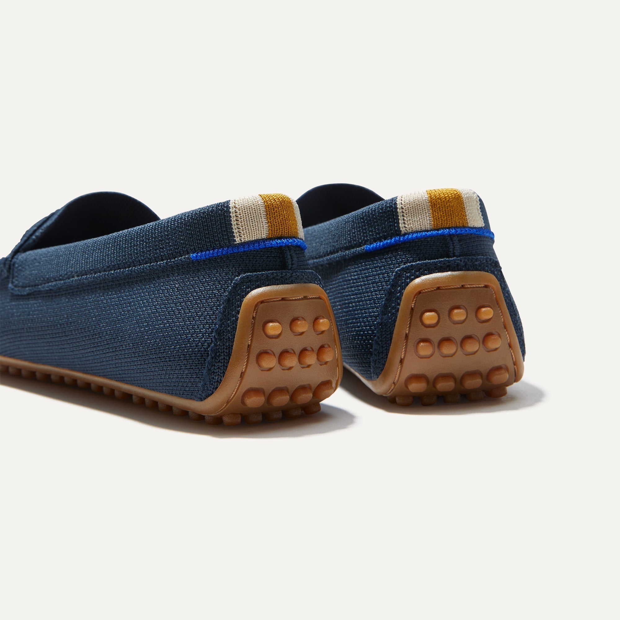 Close up of the heel of The Driver in Navy, with raised nub outsoles and Rothy's signature blue halo.