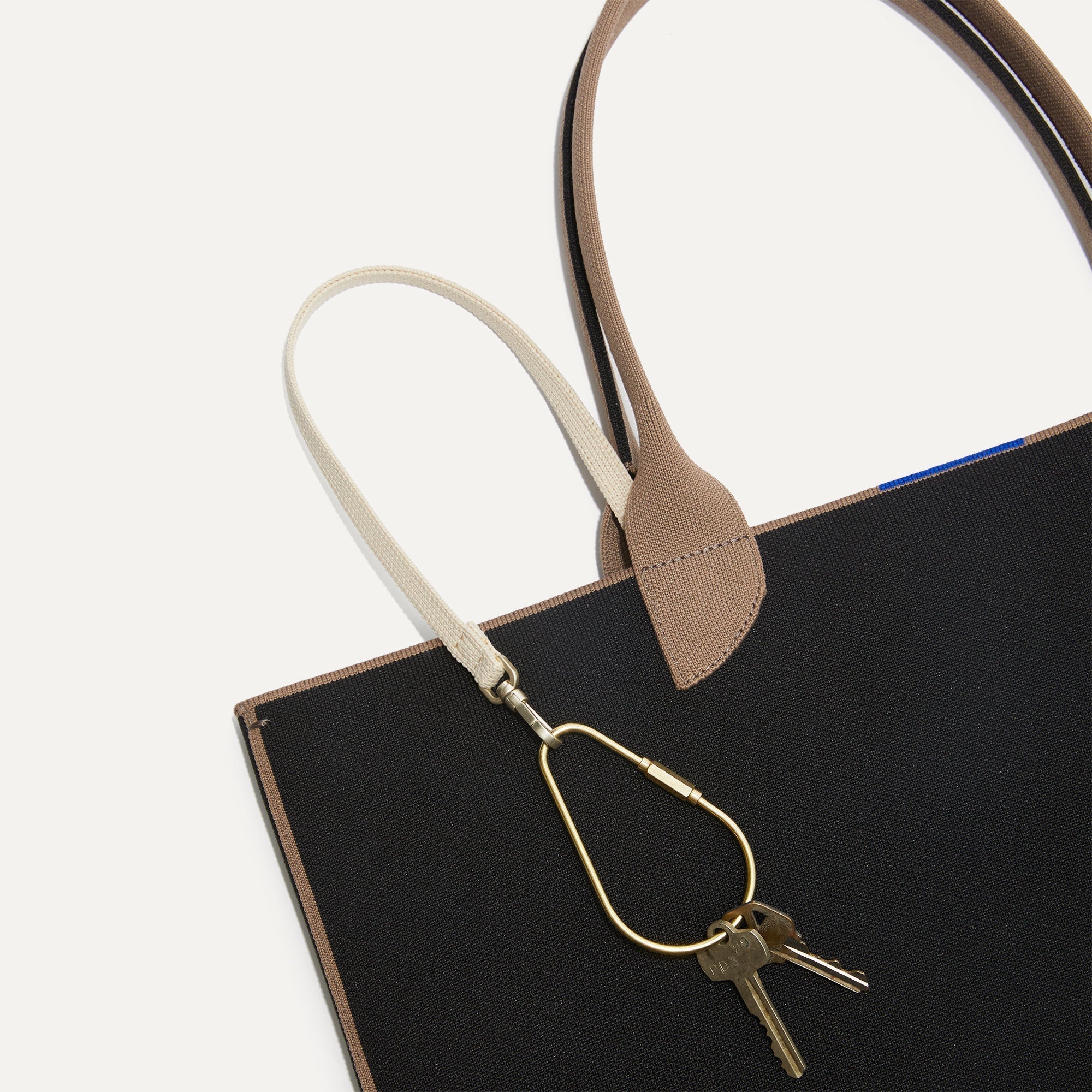 Close up of the handles and key leash detail of The Lightweight Tote in Black Portobello.