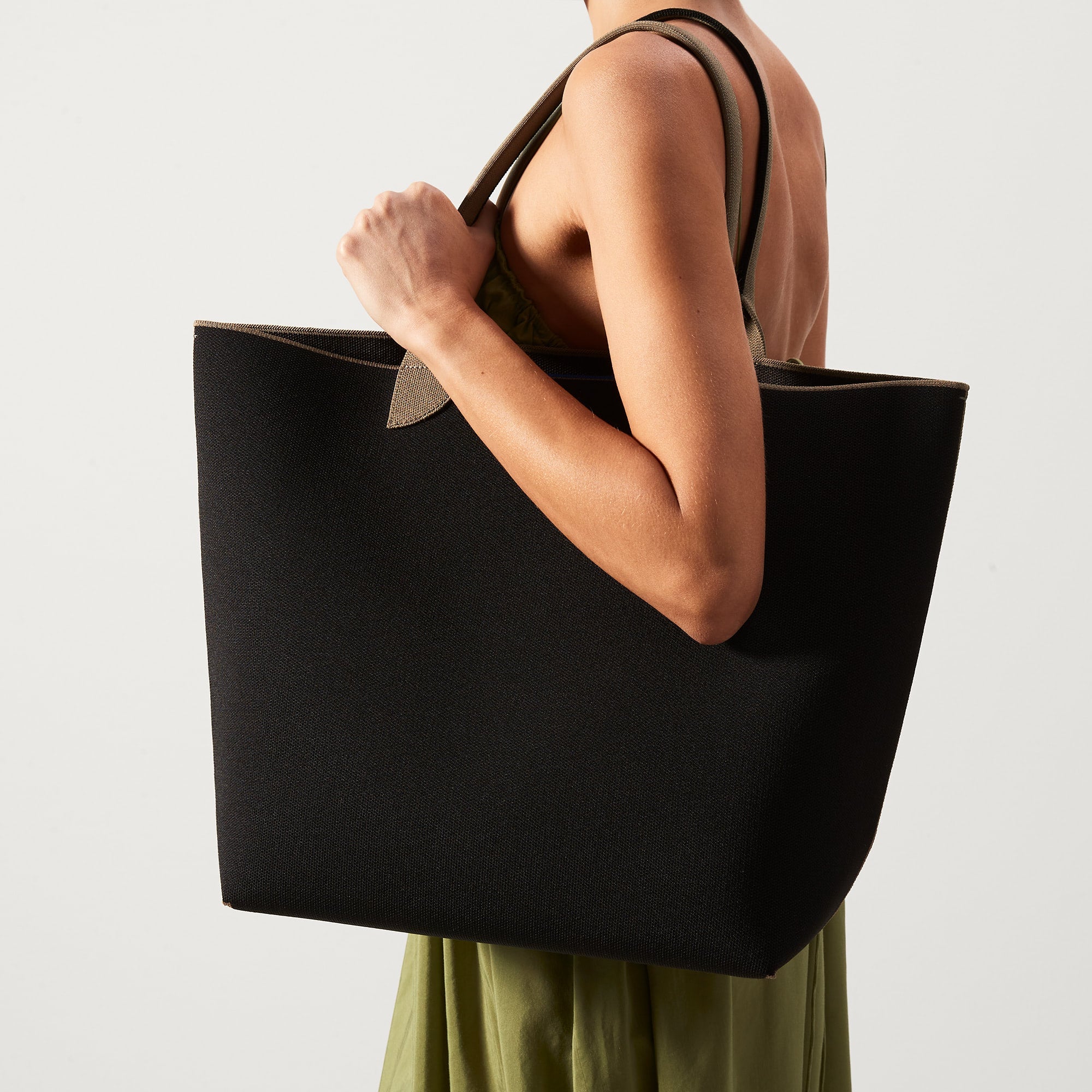 hover | Model holding The Lightweight Tote in Black Portobello.