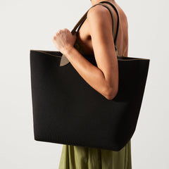 hover | Model holding The Lightweight Tote in Black Portobello.