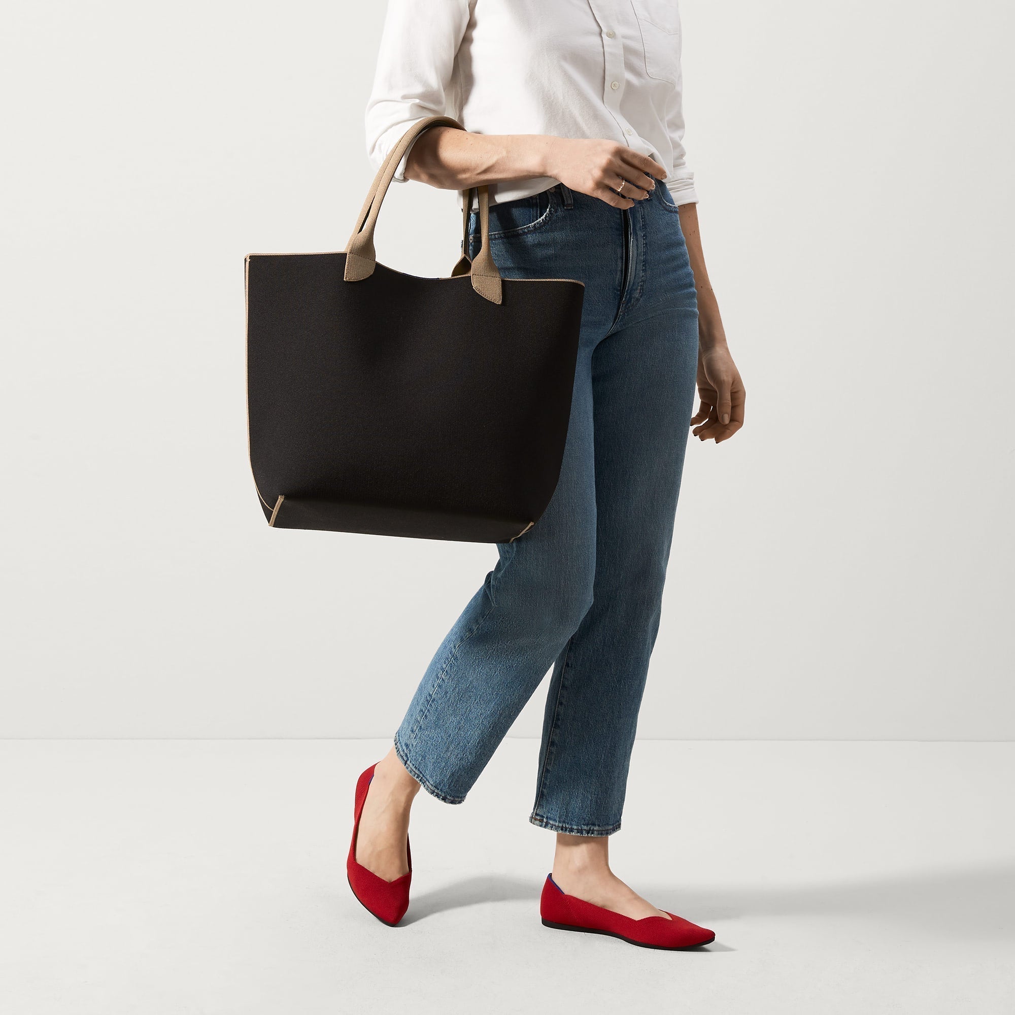 An alternate view of model holding The Lightweight Tote in Black Portobello.