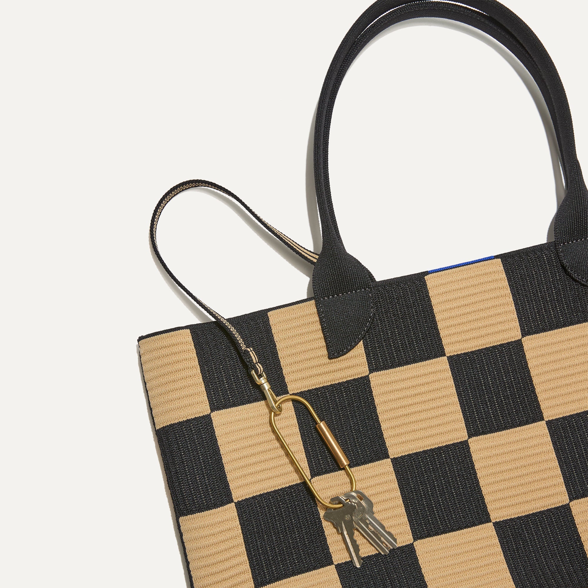 Close up of the handles and key leash detail of The Lightweight Tote in Checker Classic.