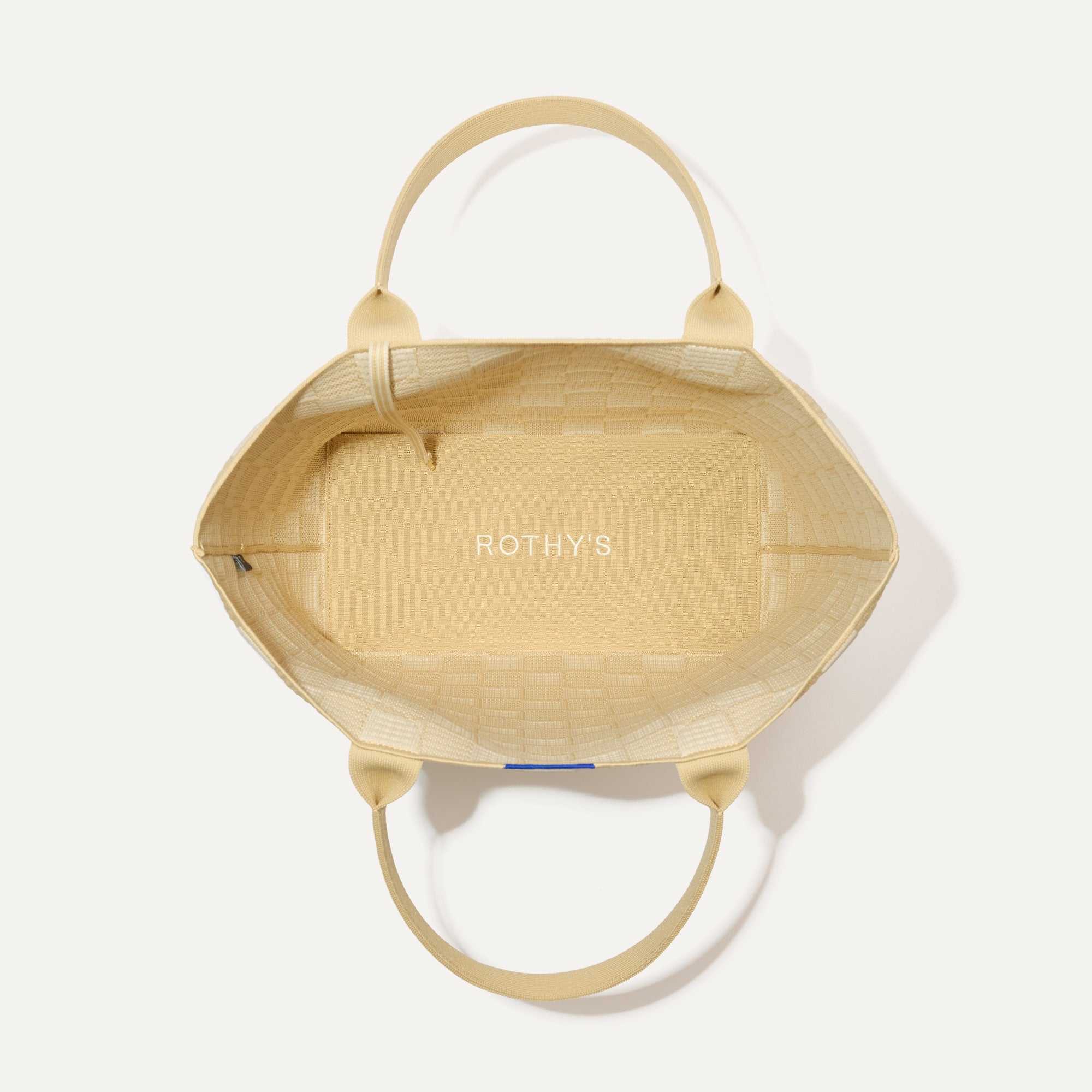 The Lightweight Tote in Checker Sand shown open from the top, with interior visible. 