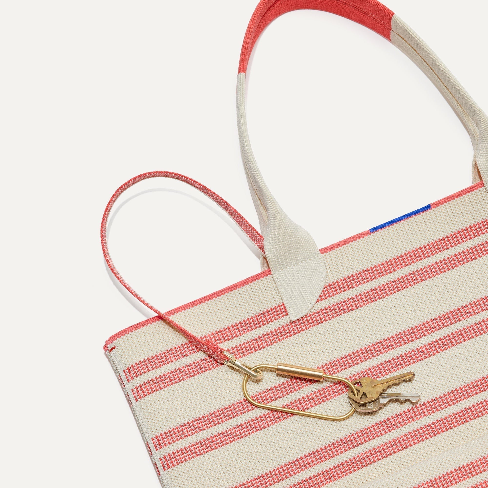 Close up of the handles and key leash detail of The Lightweight Tote in Coral Stripe.