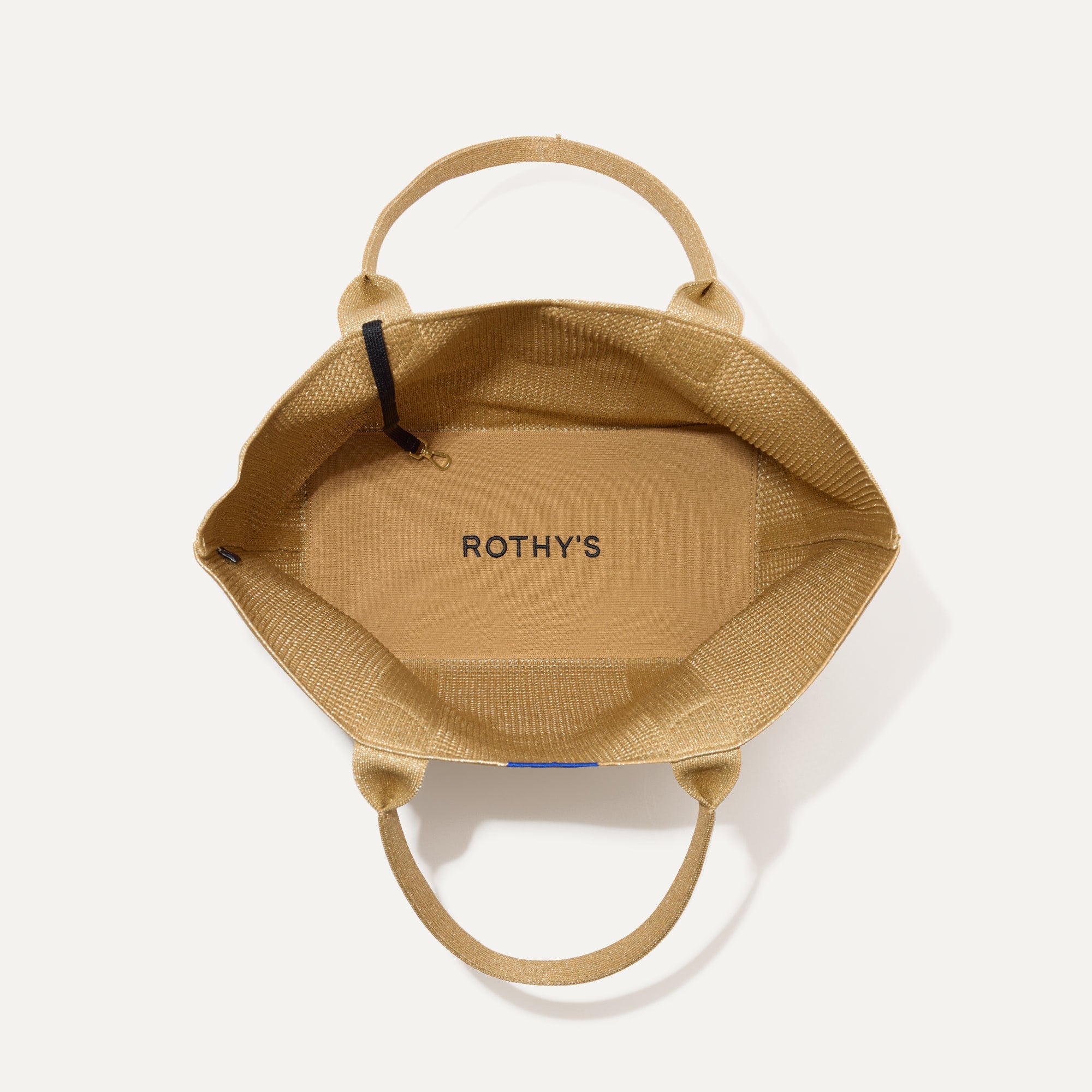 The Lightweight Tote in Golden Perf shown open from the top, with interior visible. 