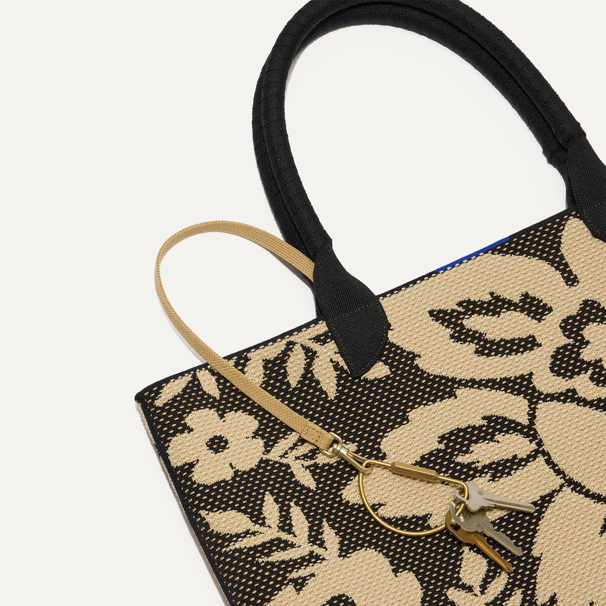 Close up of the handles and key leash detail of The Lightweight Tote in Jardin Black.