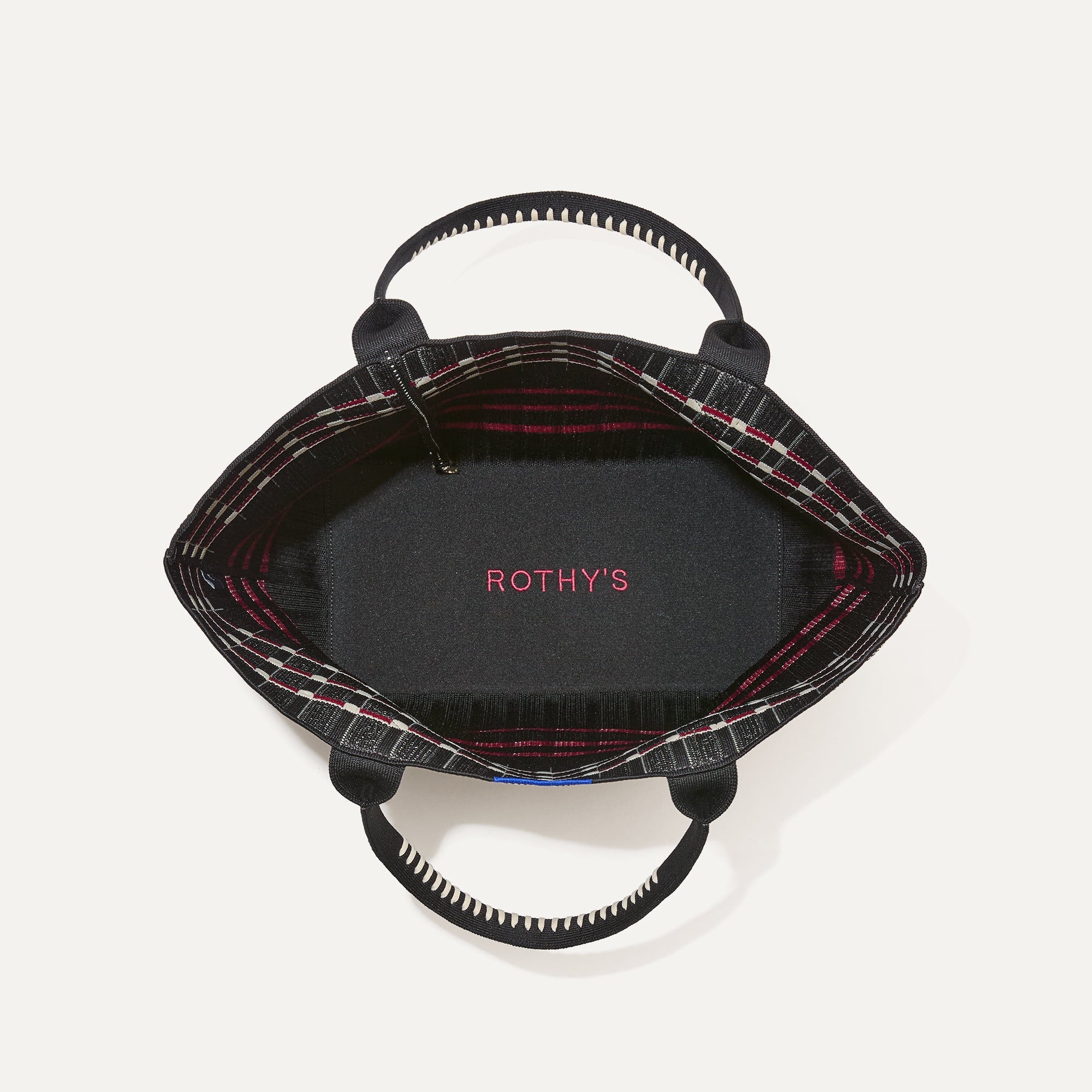 The Lightweight Tote in Newspaper shown open from the top, with base insert visible. 