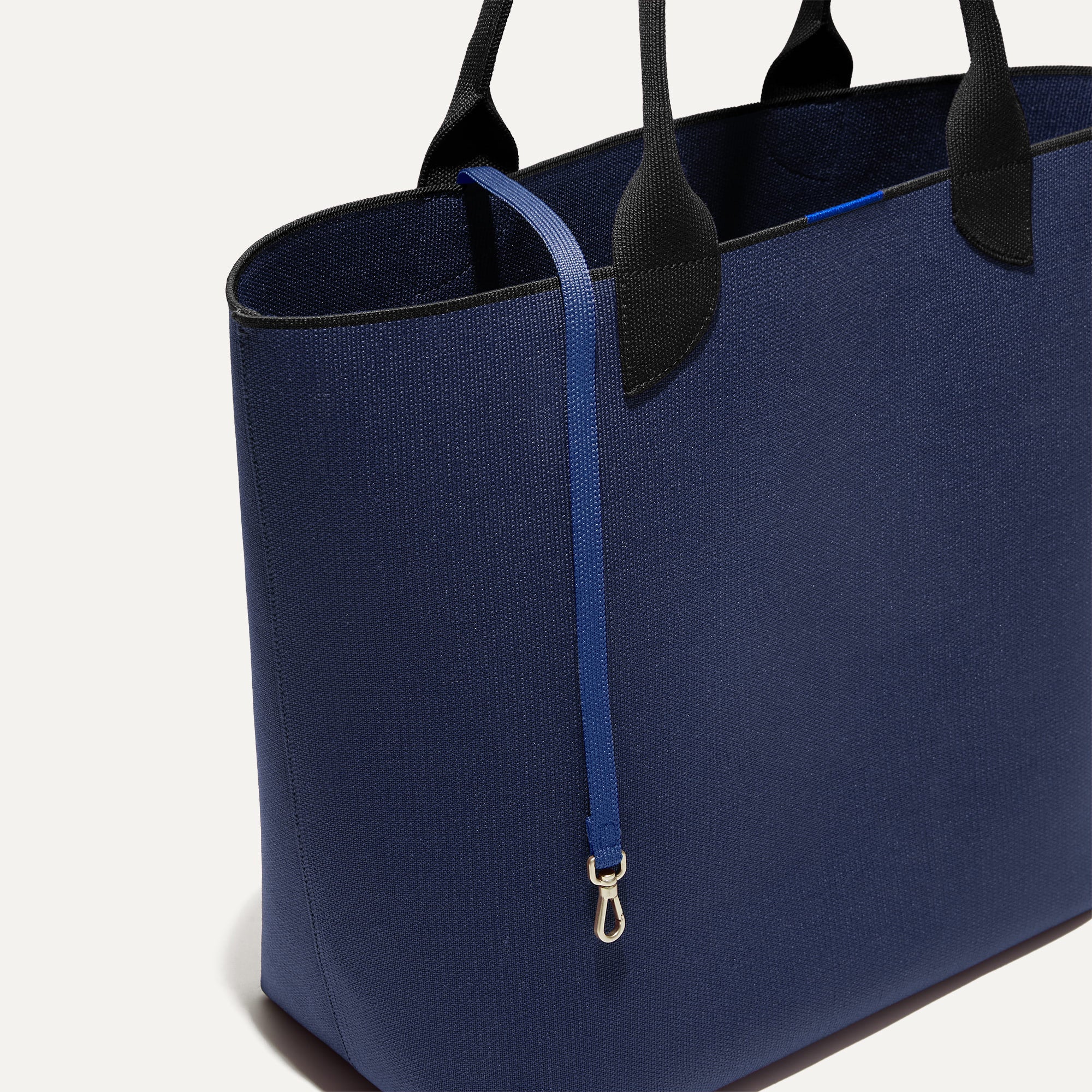 The Lighweight Tote in Sapphire and Onyx shown with its handy key leash.