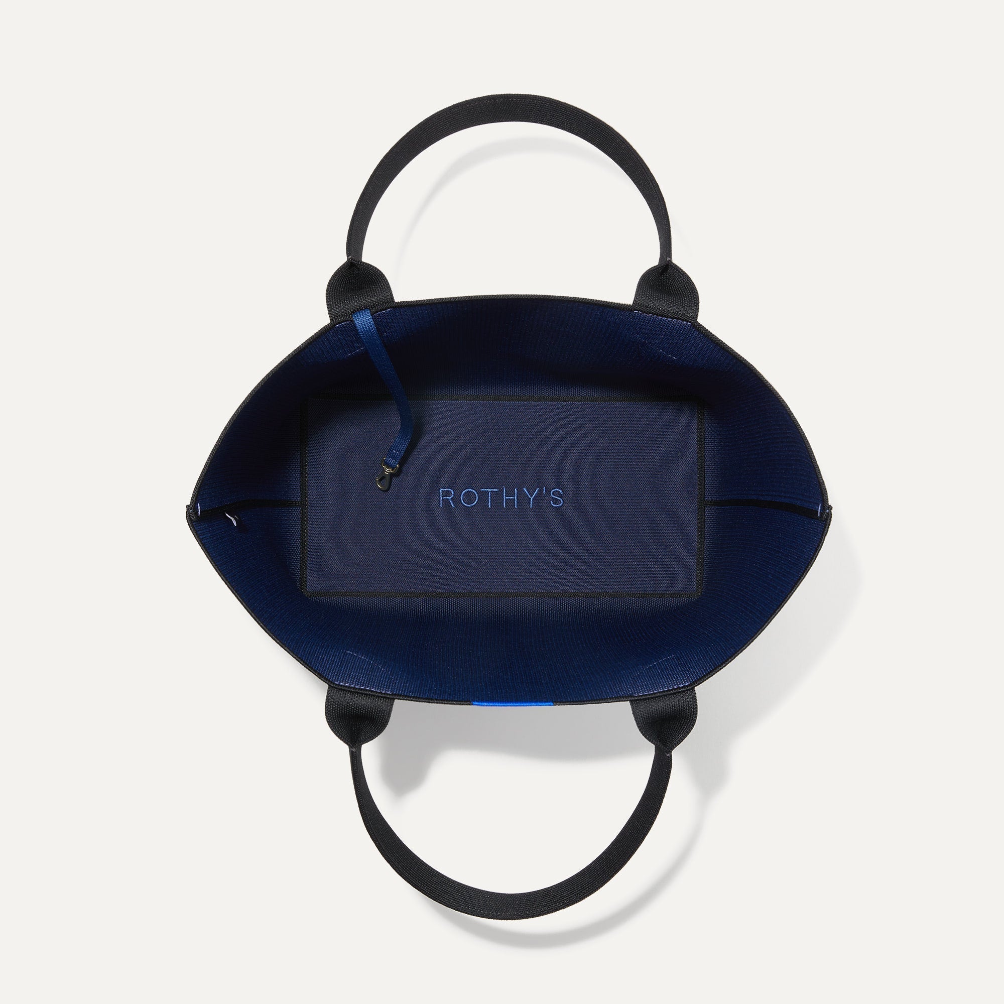 The Lightweight Tote in Sapphire and Onyx shown open from the top, with base insert visible. 
