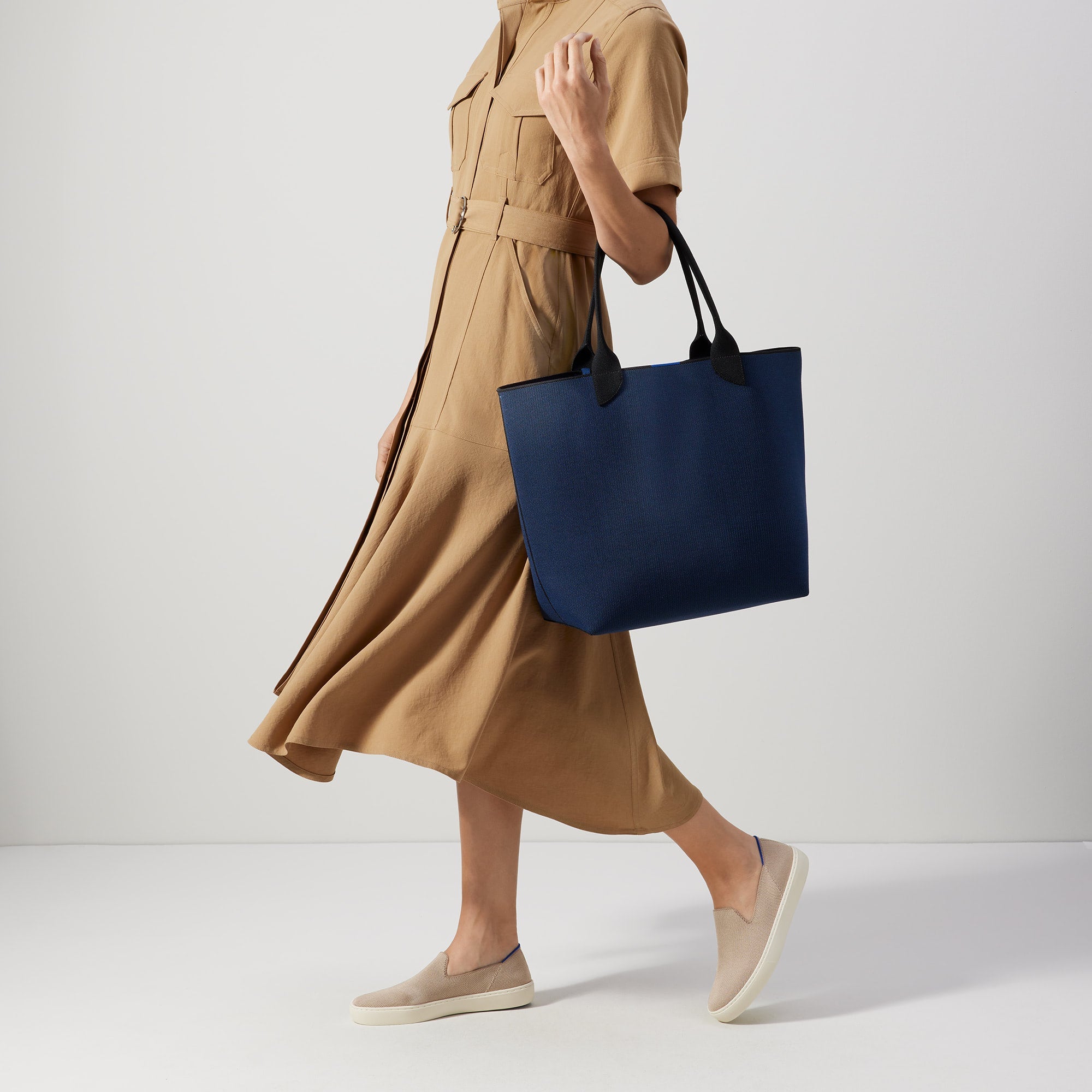 An alternate view of model holding The Lightweight Tote in Sapphire and Onyx.