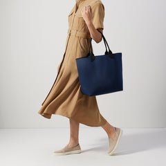 An alternate view of model holding The Lightweight Tote in Sapphire and Onyx.