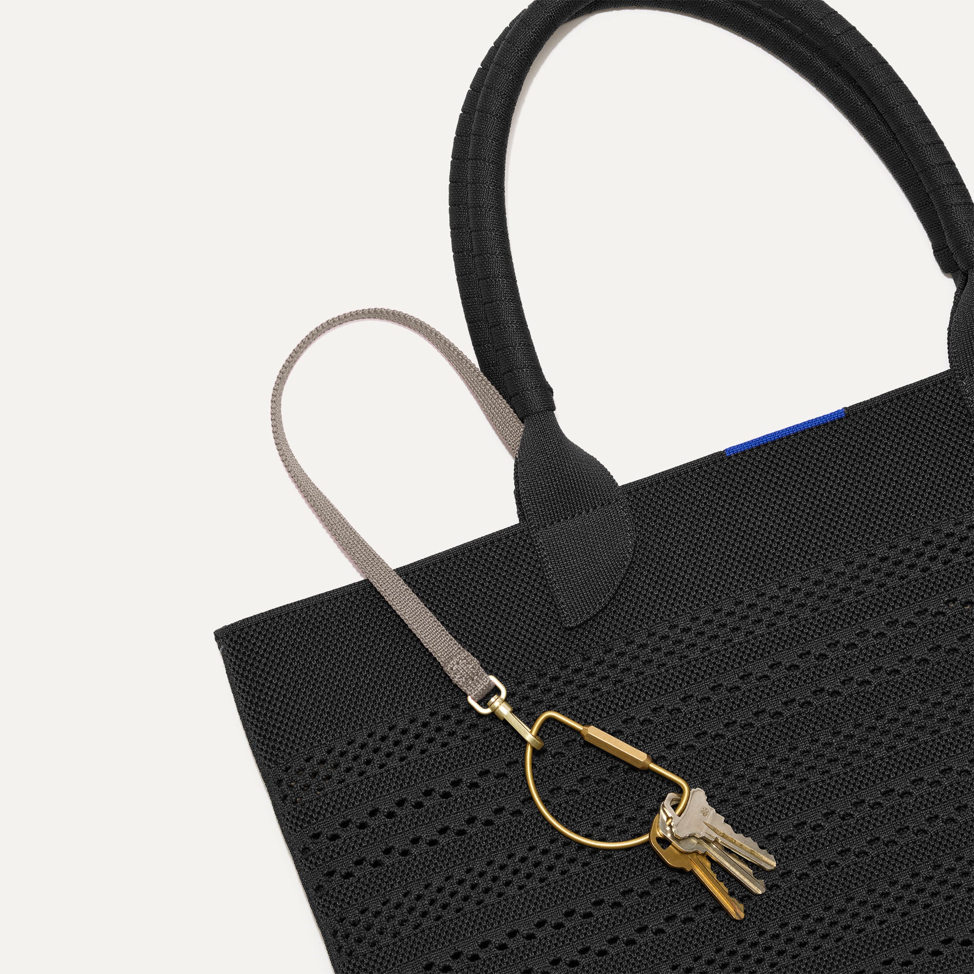 Close up of the handles and key leash detail of The Lightweight Tote in Black Crochet.