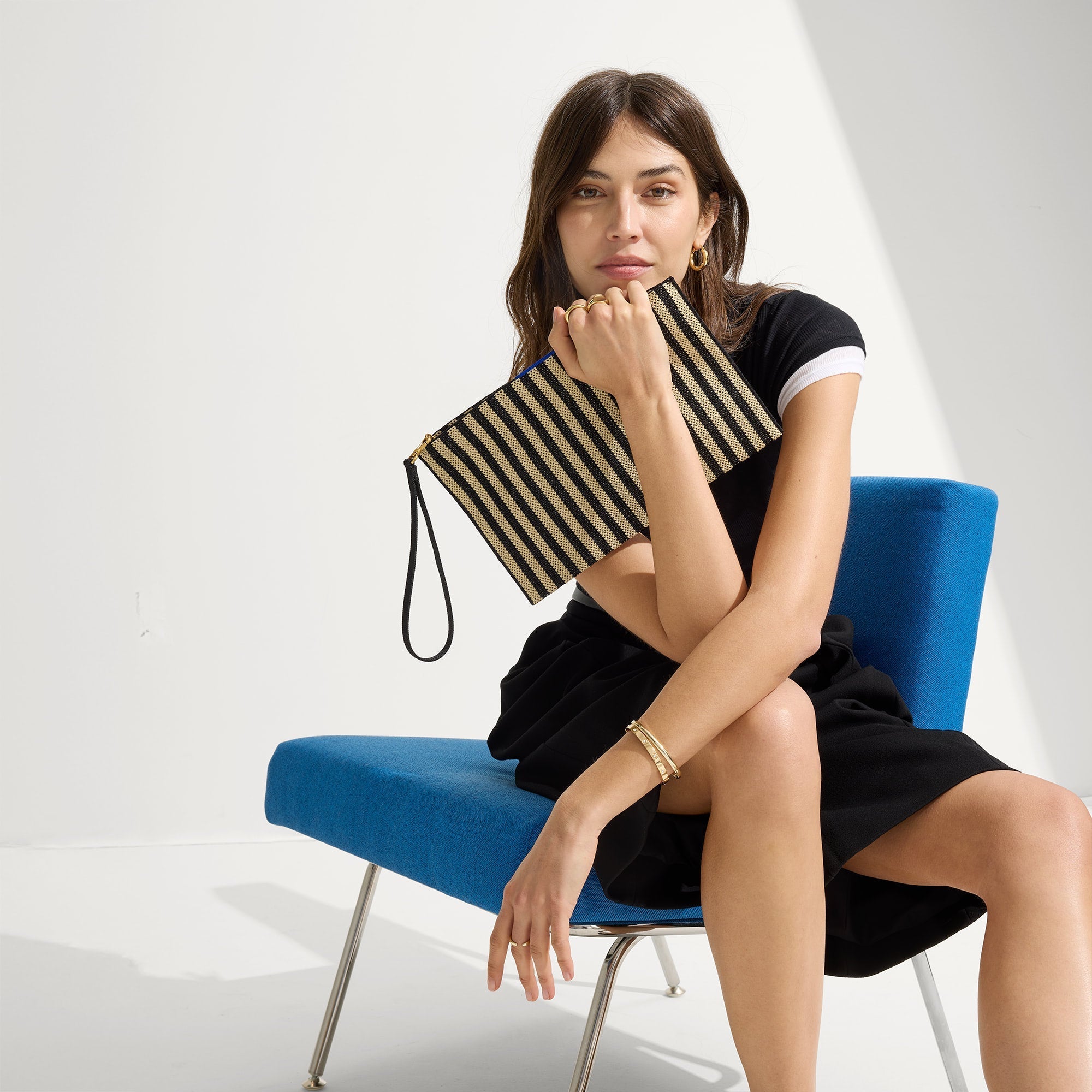 hover | The Wristlet in Black Tie held by a model shown from the front.