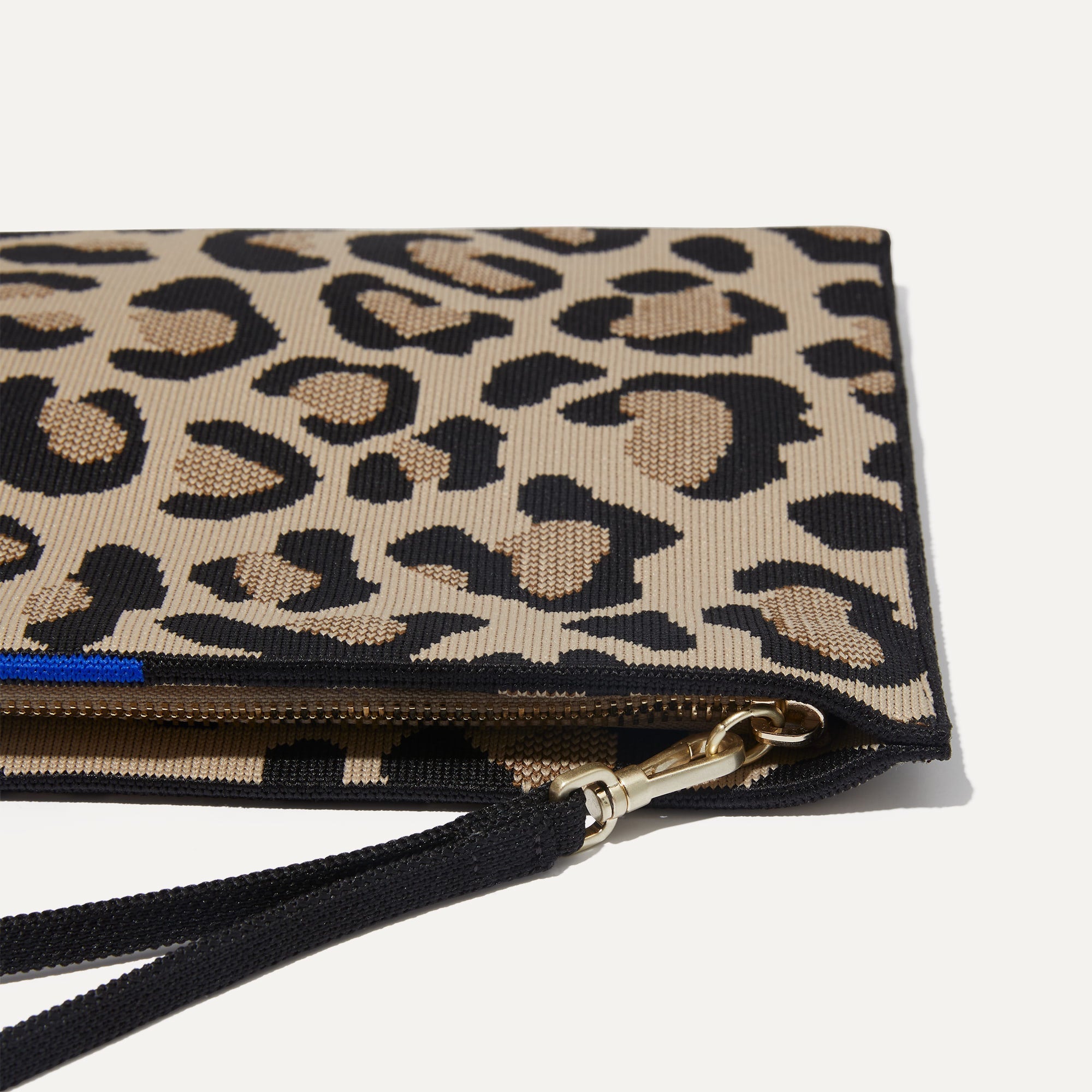 Close up of the zipper closure and wrist strap of The Wristlet in Desert Cat.