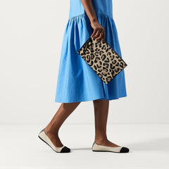 An alternate view of a model holding The Wristlet in Desert Cat.