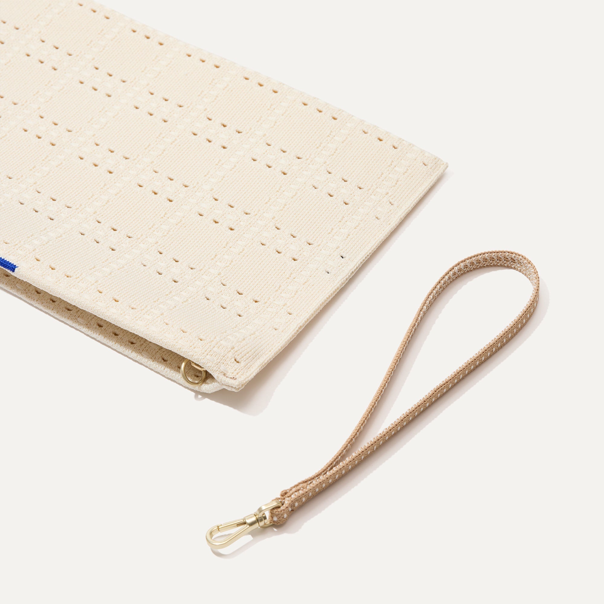 A closeup of The Wristlet in Ivory Perf, focusing on the wrist strap.