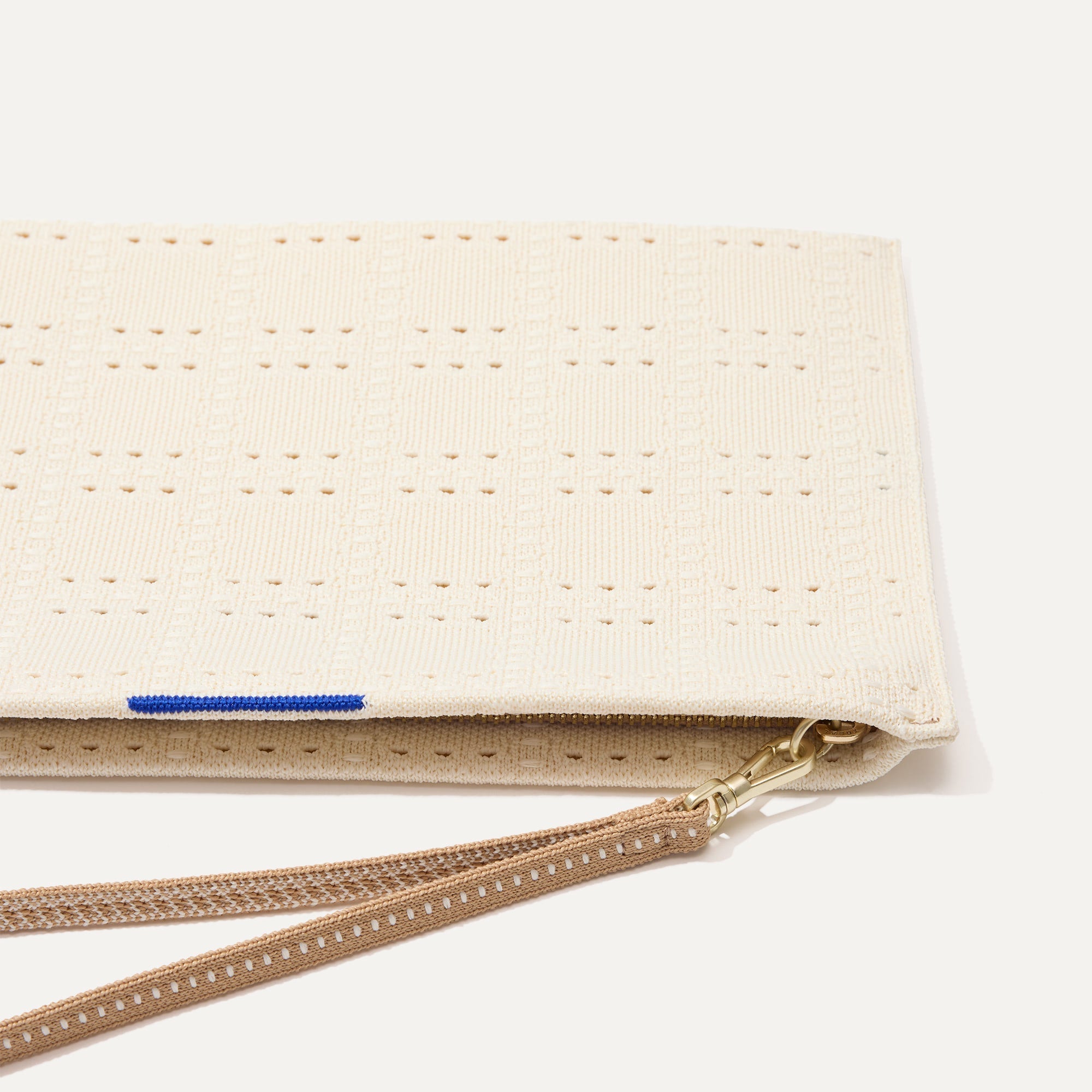 A closeup of The Wristlet in Ivory Perf, focusing on the wrist strap.