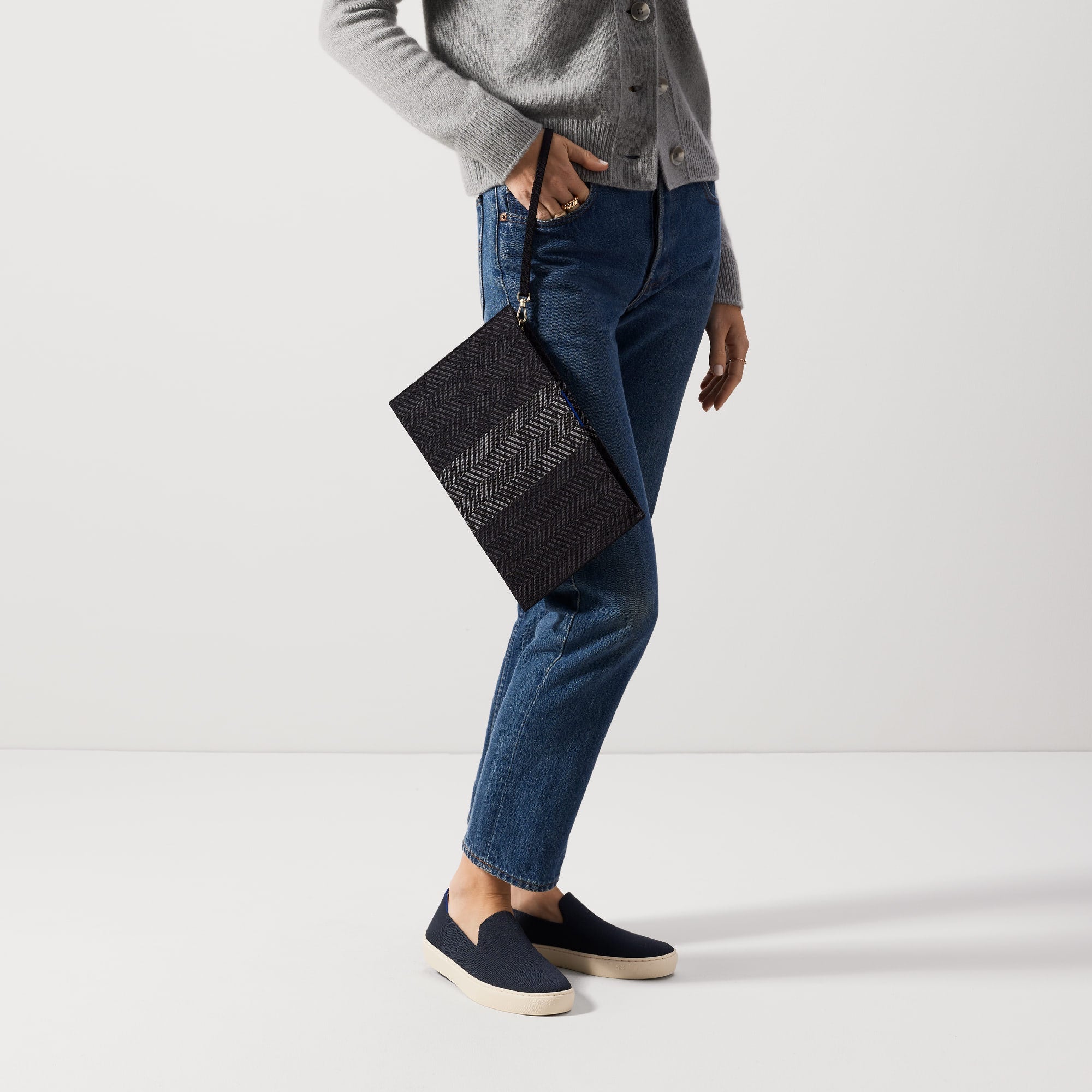 An alternate view of a model holding The Wristlet in Shadow Black.