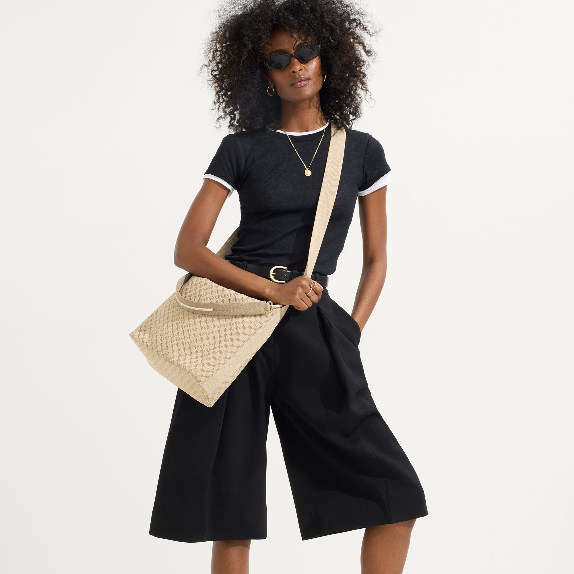 hover | The Mini Zip Bucket in Knot Brown, carried over the shoulder of a female model, shown from the front.