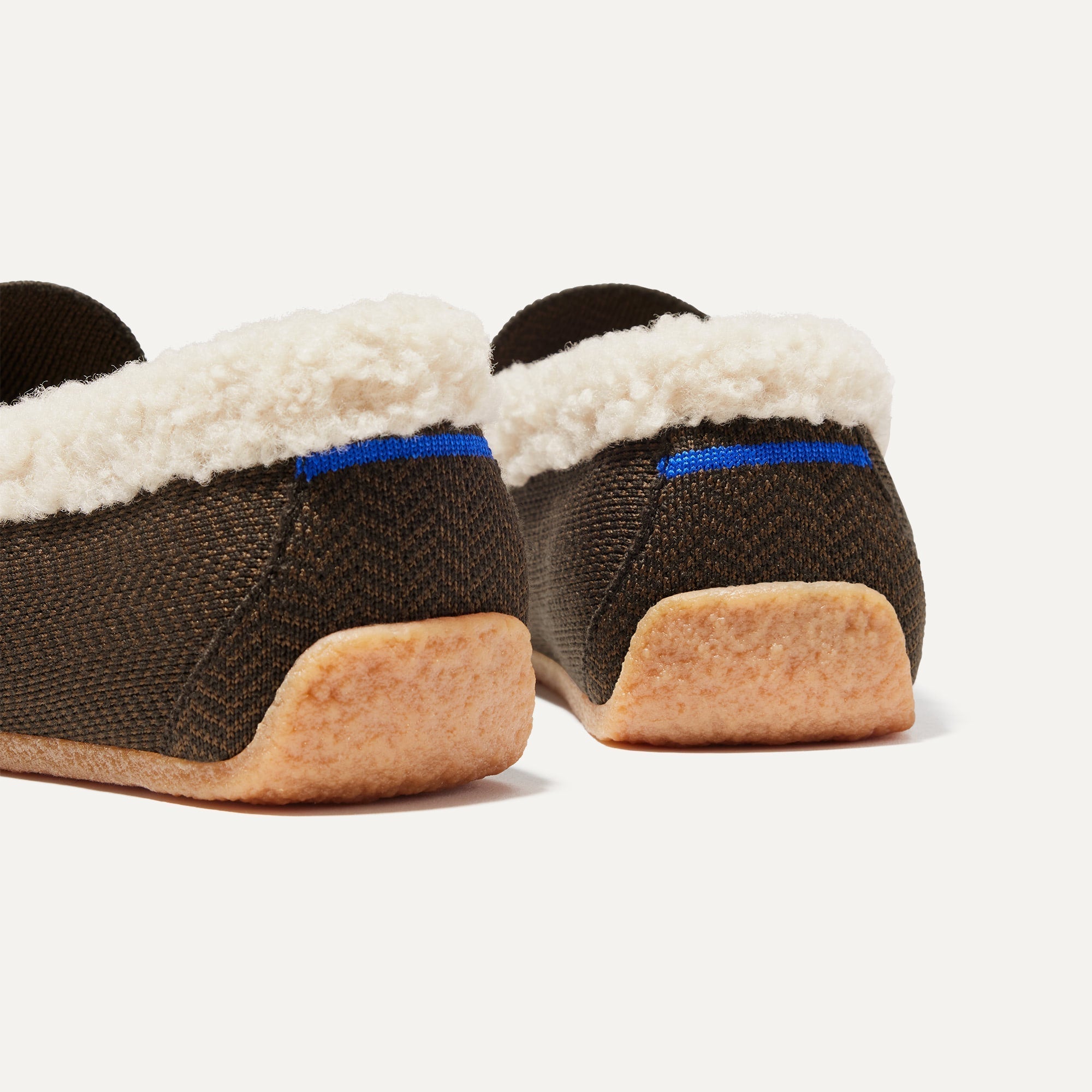 Close up of the heel of The Men's Slipper in Mahogany Herringbone, with Rothy's signature blue halo. 