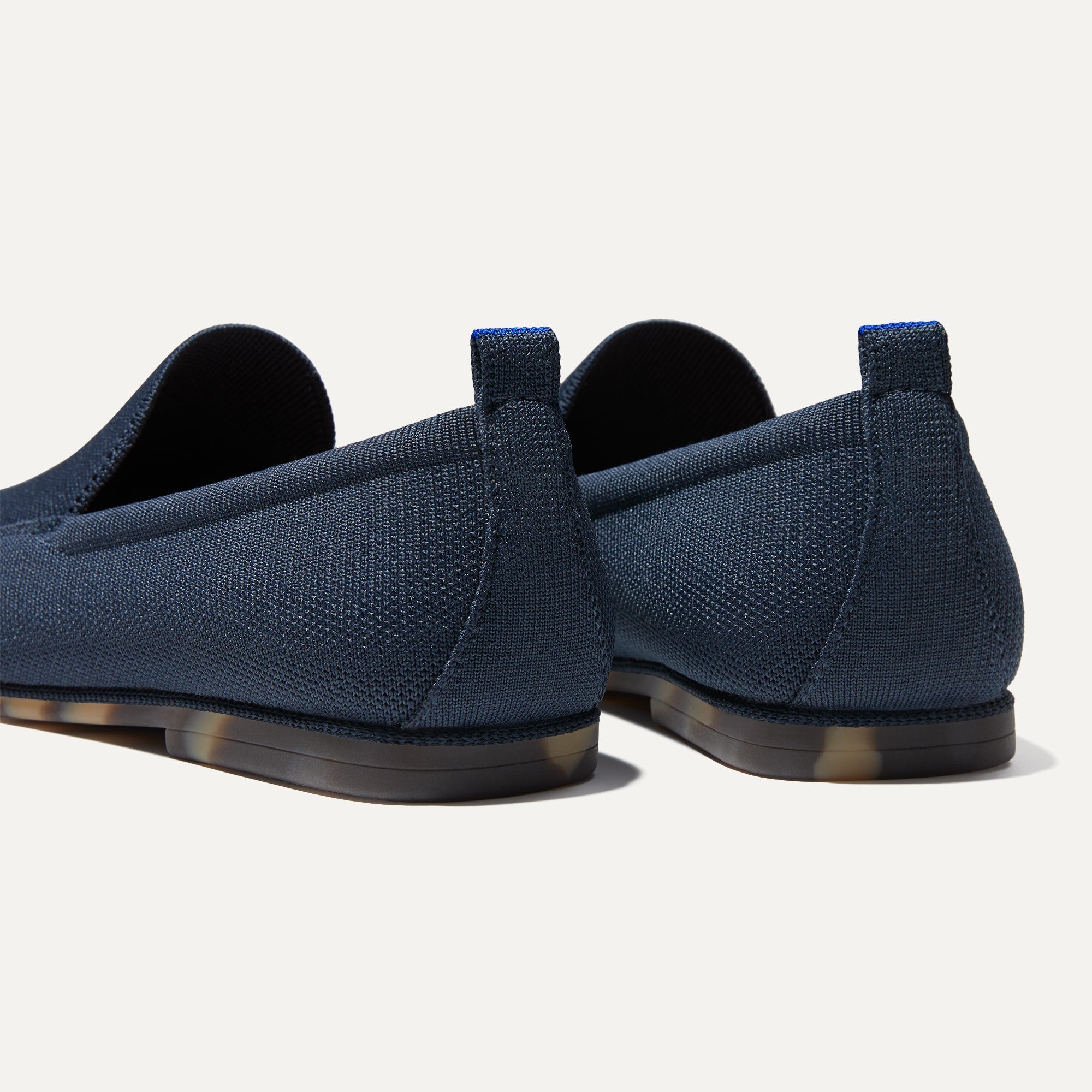Close up of the heel of The Ravello Loafer in Navy, with Rothy's signature blue halo on the pull tab.