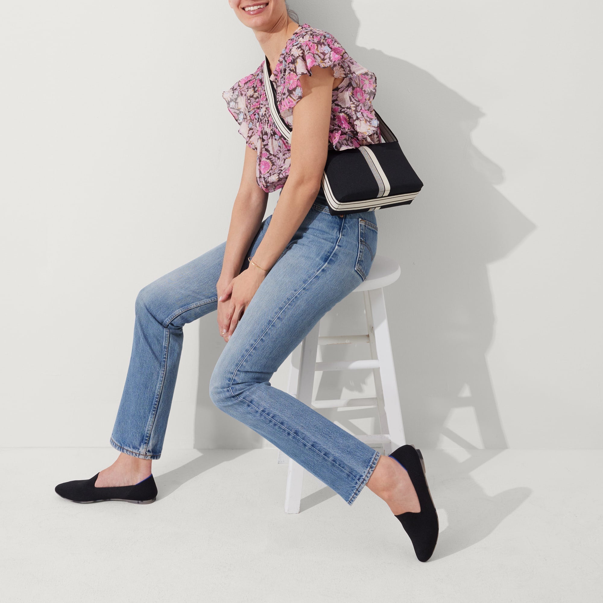 The Casual Crossbody in Black & Ivory Stripe, worn as a crossbody by a model, shown from the side. 