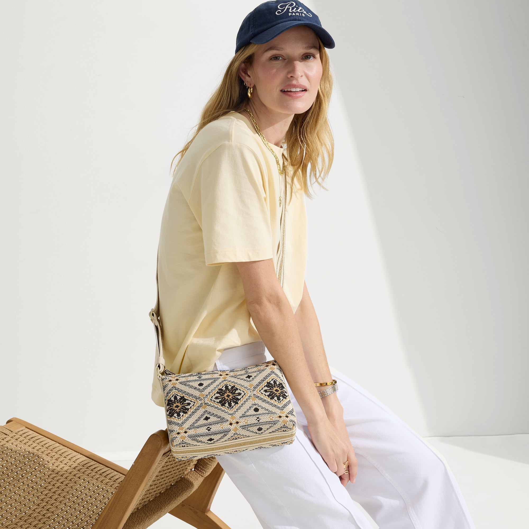 The Casual Crossbody in Desert Mosaic, carried by its crossbody strap by a model, shown in motion.