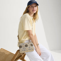 The Casual Crossbody in Desert Mosaic, carried by its crossbody strap by a model, shown in motion.