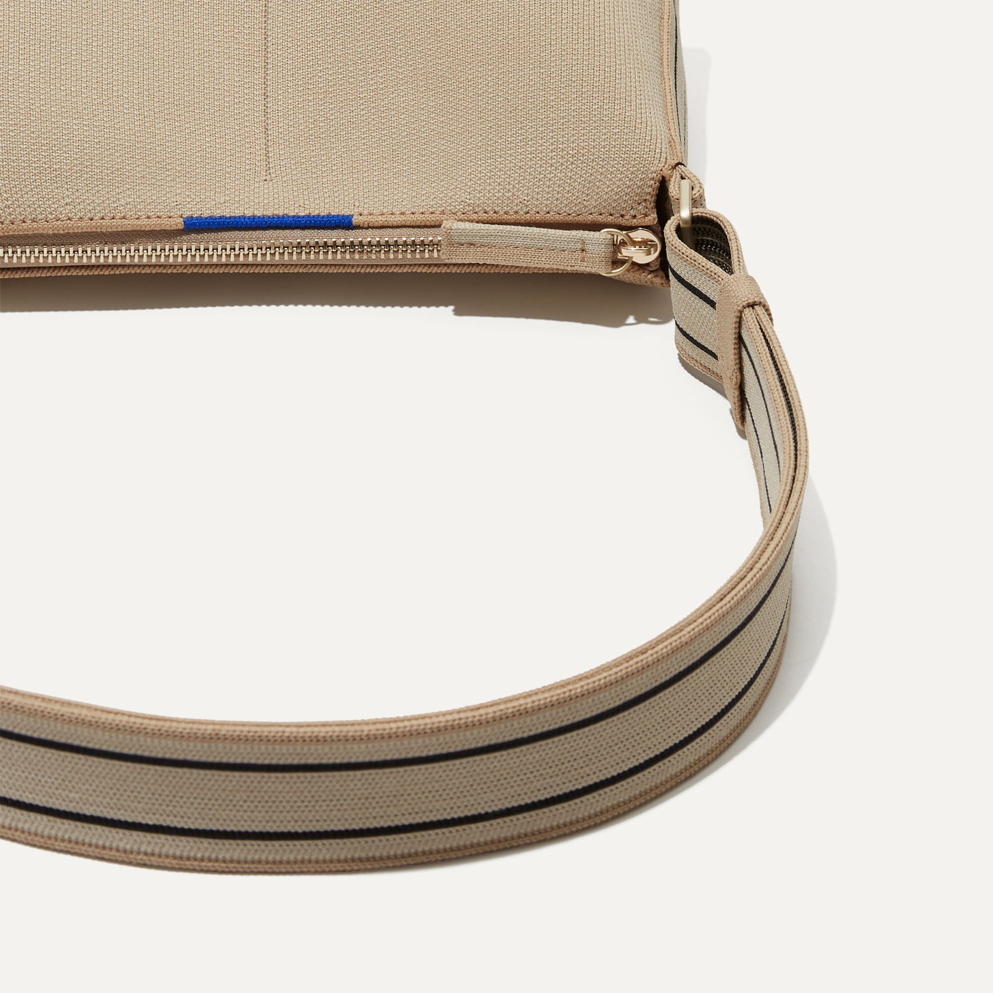 A closeup of The Casual Crossbody in Parchment, focusing on the crossbody strap. 