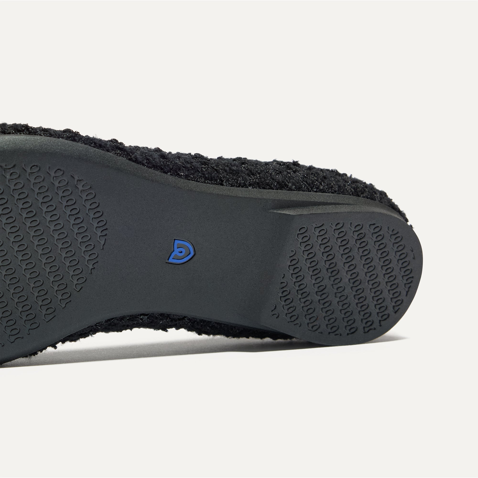 Close up of the outsole of The Point II in Black Bouclé, shown in a diagonal view. 