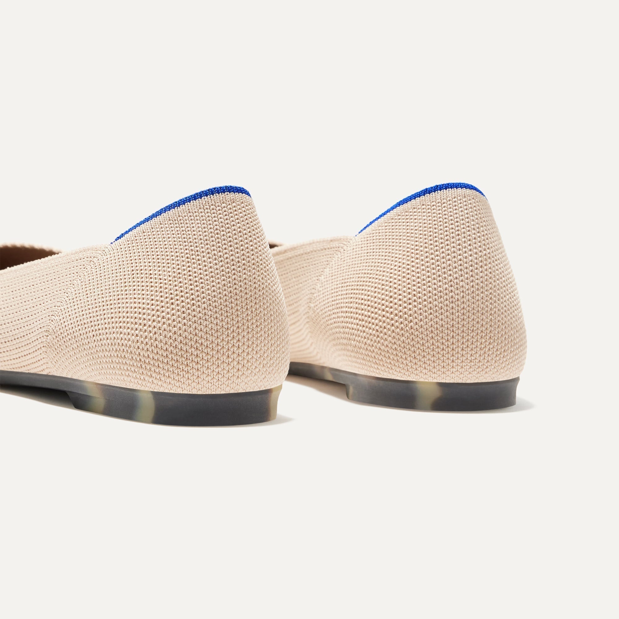 Close up of the heel of The Point II in Ecru, with Rothy's signature blue halo. 