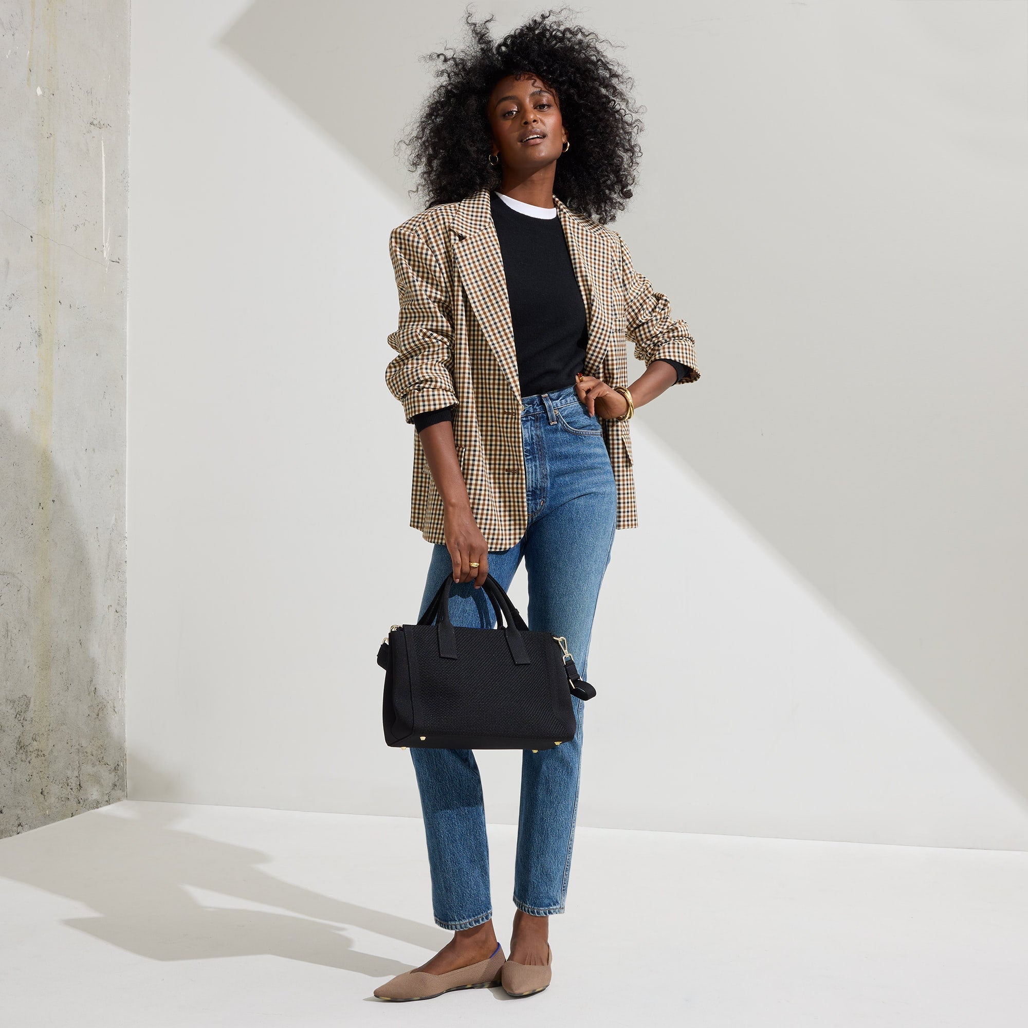 The Classic Handbag in Black shown on model in a different pose.