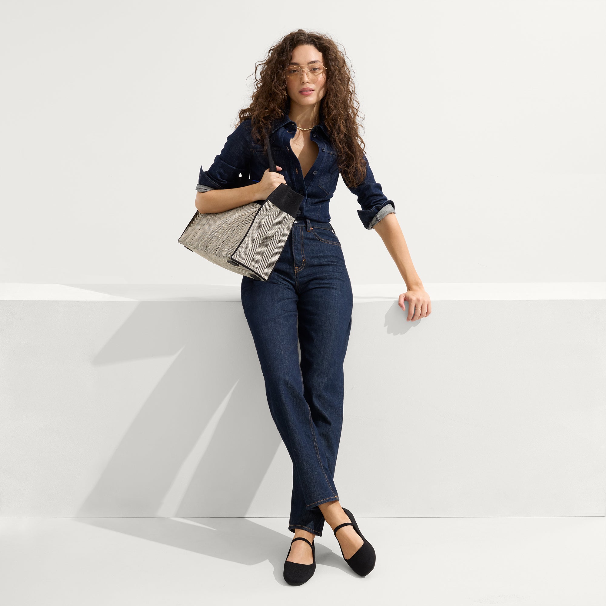 The Classic Tote in Black Herringbone, worn on the side.